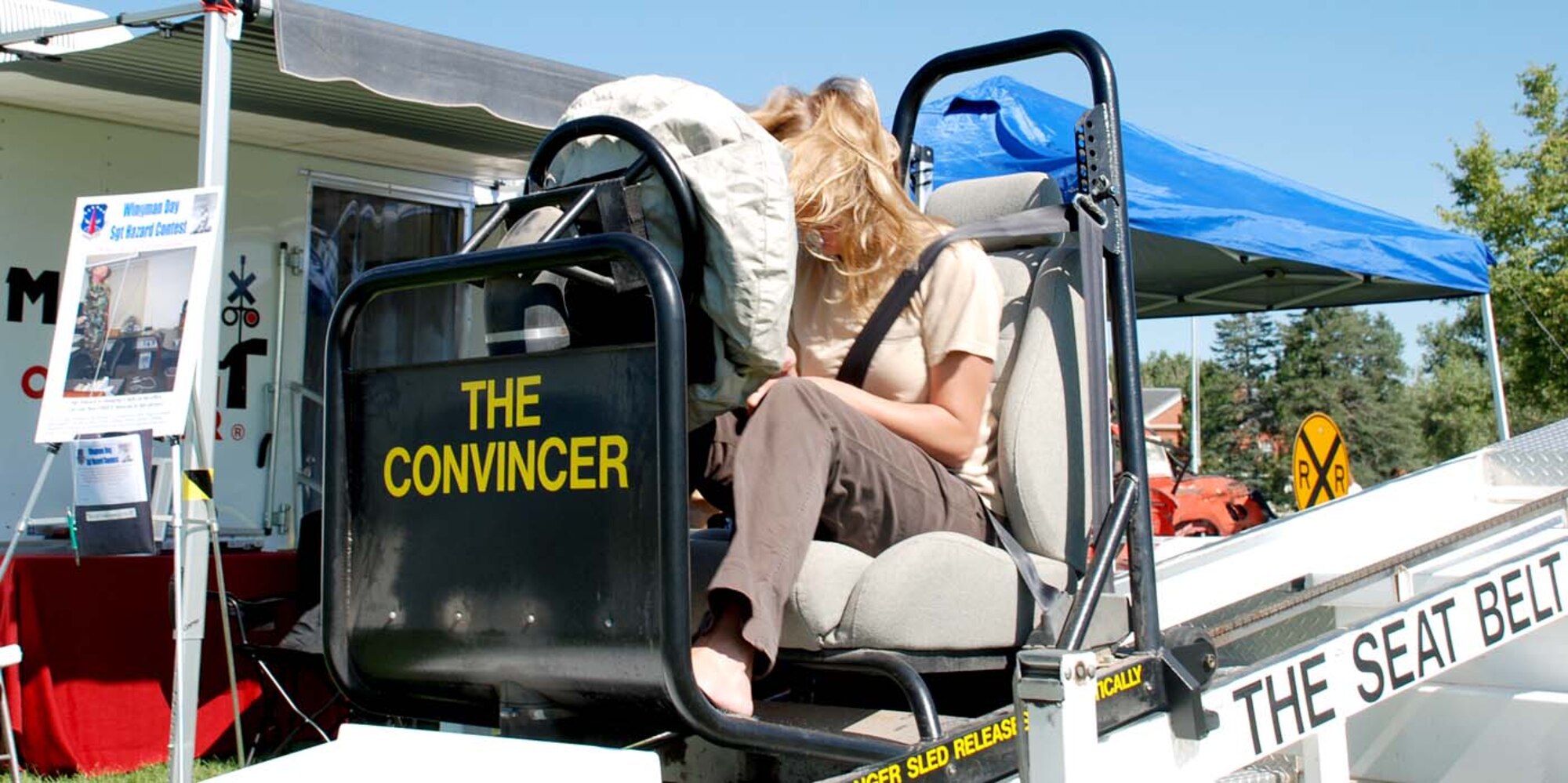 Senior Airman Holly Ruiz, 90th Comptroller Squadron, takes a ride on “The Convincer,” a seatbelt safety reminder that simulates a head-on collision at five miles per hour. Wyoming Highway Patrol sponsored the machine at Frontiercade Aug. 24 (Photo by Airman 1st Class Daryl Knee).