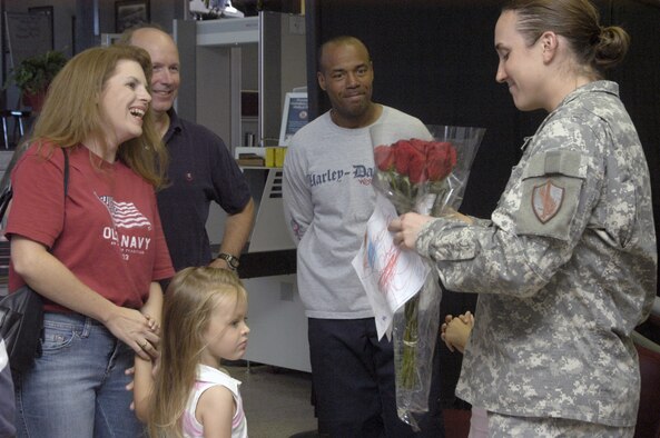Capt. Morgan Ellison, 90th Force Support Squadron, is welcomed home by coworkers Aug. 23 at the Cheyenne Regional Airport from a 135-day deployment in Afghanistan. Captain Ellison received a purple heart after she was injured in an attack on her convoy near Kabul, Afghanistan May 6. Although she was offered a less hazardous duty after her recovery, Captain Ellison returned to her previous job and finished her deployment there (Photo by 2nd Lt. Lisa Meiman).