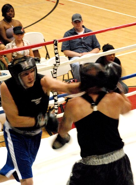Second Lt. Derrick Burks, 90th Missile Security Forces Squadron, connects with a left hook on his opponent, Airman 1st Class Matt Smith, 50th Civil Engineer Squadron, Schreiver Air Force Base, Colo., during the Warren Invitational Boxing Exhibition Aug. 24 at the Fall Hall Community Center here. Lieutenant Burks won his match in a split decision (Photos by Staff Sgt. Chad Thompson).