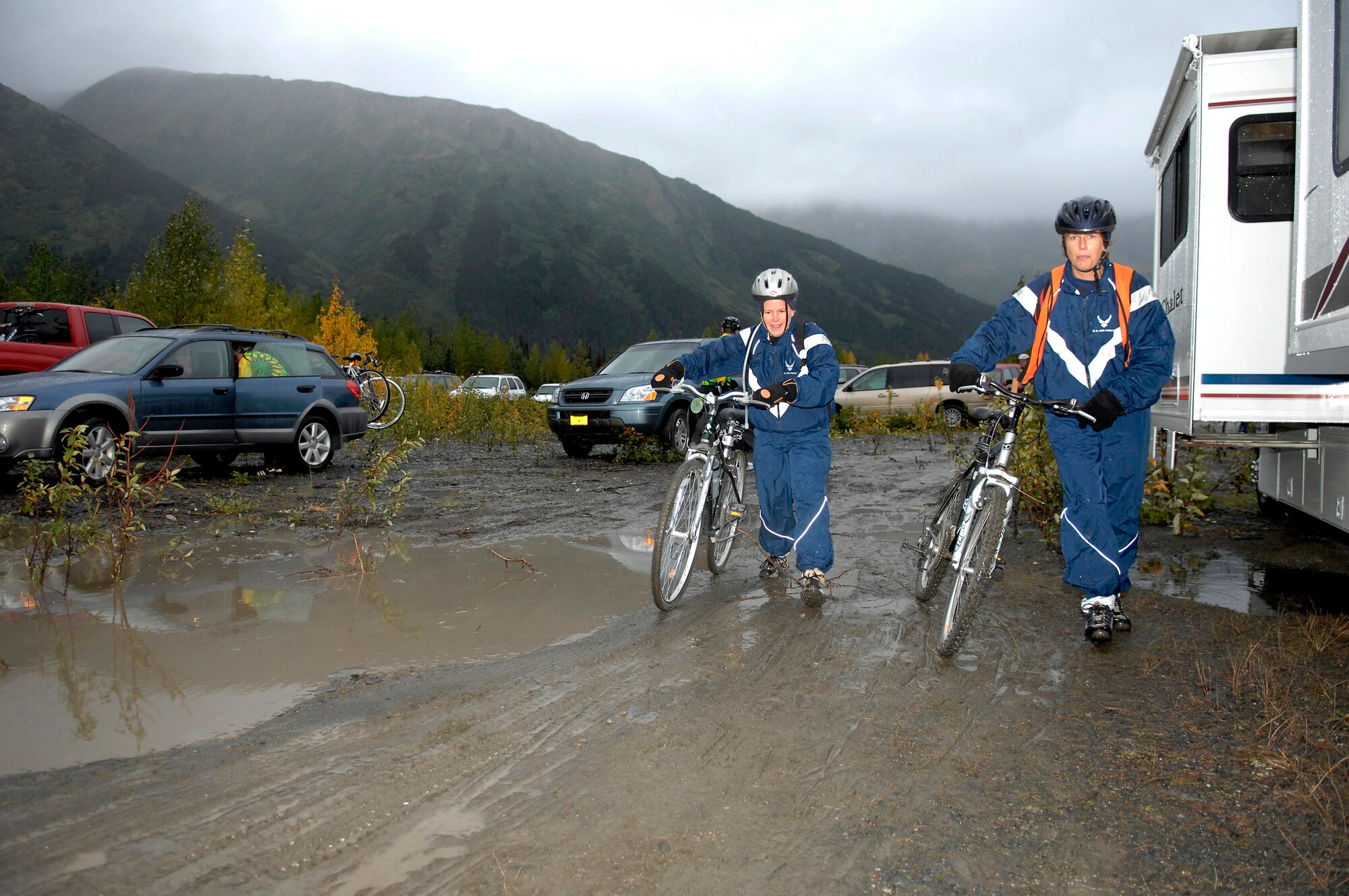 KENAI PENINSULA, ALASKA -- Maj. Julie Ostrand and Capt. Wendy Koehler dodge mud and water as they arrive in Seward after completing the first leg of the Alaska MS Bike Ride. The ride took participants from Mile Post 63 on the peninsula along the Seward Highway to Seward, Alaska. Consistent and sometimes heavy rains didn't prevent Major Ostrand and Captain Koehler, both nurse practitioners at the 3rd Medical Group, and other 'Arctic Warriors' from Elmendorf Air Force Base, from completing the ride, which took place Sept. 8 and 9. People who took the 126-mile round trip ride saw extreme elevation gains challenging even the most experienced of the 200 riders. All proceeds from this event raised money for the Nation Multiple Sclerosis Society. (U.S. Air Force photo by Tech. Sgt. Keith Brown)
