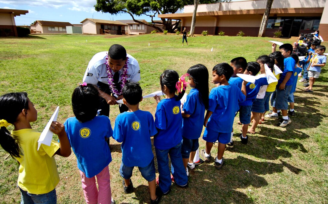Senior Airman Andrew William helps children from August Ahrens Elementary School in Waipahu, Hawaii, prepare their paper airplanes for a distance contest Sept. 10 during Air Force Week Honolulu. Approximately 800 Airmen from Hickam Air Force Base, Hawaii, spent their day at 80 local schools on the island of Oahu reading, playing and educating children about the Air Force. Airman William is with the 15th Civil Engineer Squadron. (U.S. Air Force photo/Tech. Sgt. Shane A. Cuomo) 