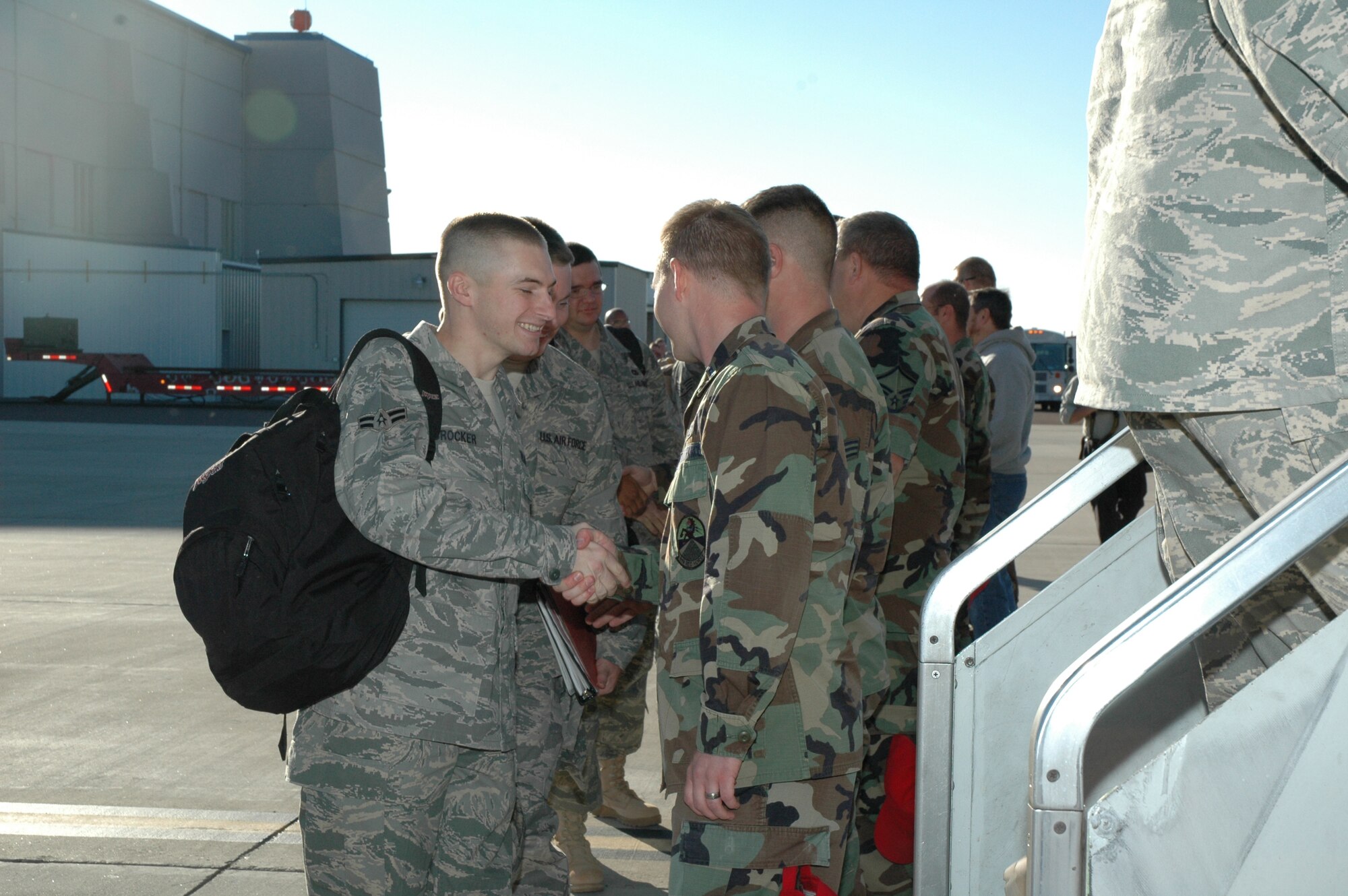 Airman 1st Class Billy Crocker shakes hands with 1st Lt. Jeff Klein, 819th RED HORSE Squadron, prior to boarding the plane for a deployment to southwest Asia. Nearly 200 members of the 819th RHS deployed on Sept. 11 in support of the Global War on Terrorism. (U.S. Air Force photo / Airman 1st Class Emerald Ralston)