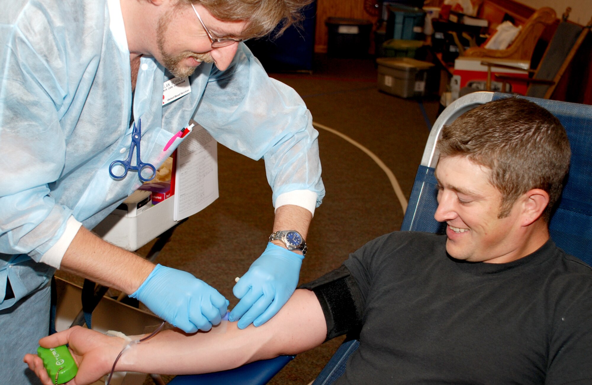 Tech. Sgt. Nick Weiers, 90th Maintenance Operation Squadron, donates blood in the chapel activity center here Aug. 14. Alan Schultz draws the blood and has been working in this field for 11 years. The American Red Cross crew has preformed 226 draws since Jan. 4 (Photo by Airman 1st Class Daryl Knee).
