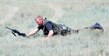 Tech. Sgt. James Miller, 90th Security Forces Squadron, falls to the ground after a simulated gunshot during the deployment exercise Aug. 17. He and another Airmen played sniper infiltrators who were dropped off by a helicopter for the exercise (Photo by Airman Alex Martinez).