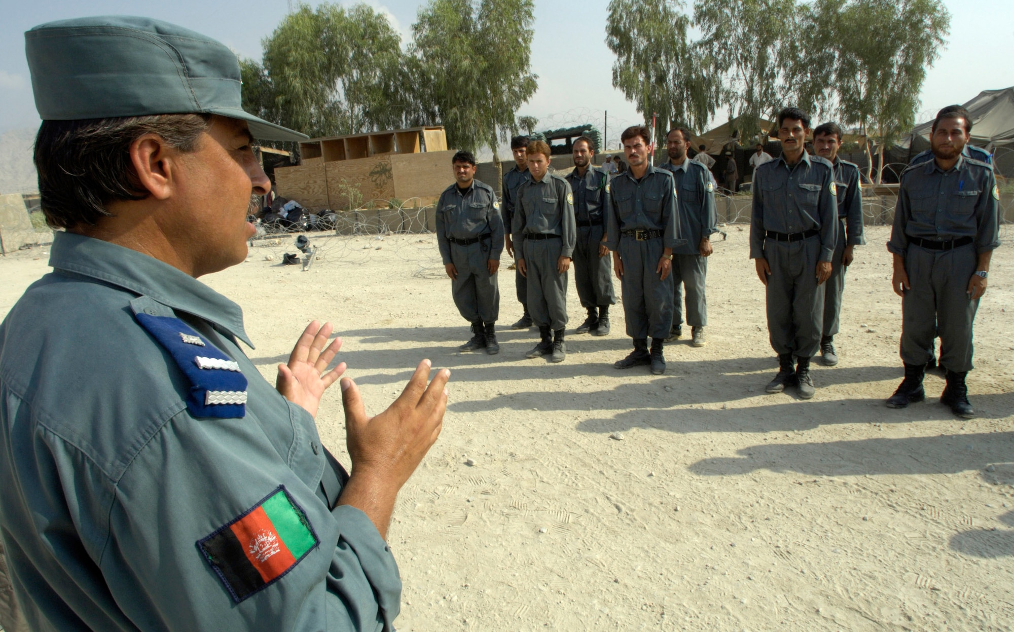 Afghan National Police Capt. Muhammad Ajan explains proper reporting procedures to Afghan National Auxiliary Police trainees during drill practice Sept. 3 at Forward Operating Base Mehtar Lam in Afghanistan's Laghman province. Afghan National police instructors are teaching the course on their own for the first time. Laghman is the first Afghanistan province to have Afghan instructors teaching an ANP course. The ANP instructors were competitively selected and completed an instructor development course taught at a regional training center. (U.S. Air Force photo/Master Sgt. Jim Varhegyi)
