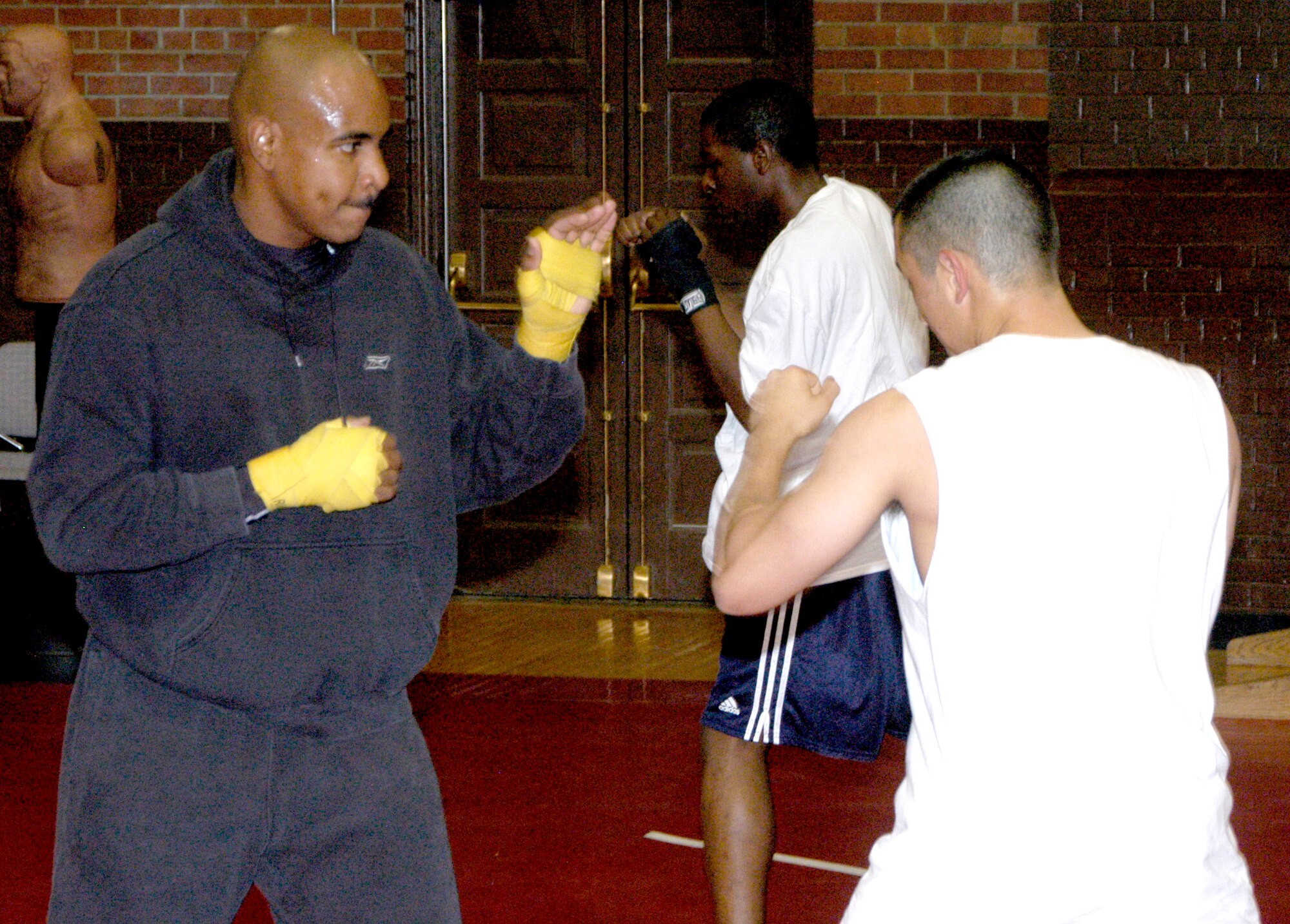 Capt. Rodney Ellison, 319th Missile Squadron, works on some basic maneuvers with Senior Airman Kurtis Buenting, 90th Missile Maintenance Squadron, during a practice Aug. 2 at the Fall Hall Community Center. Captain Ellison is the coach of the Warren boxing team and Airman Buenting has been on the team for more than one year.