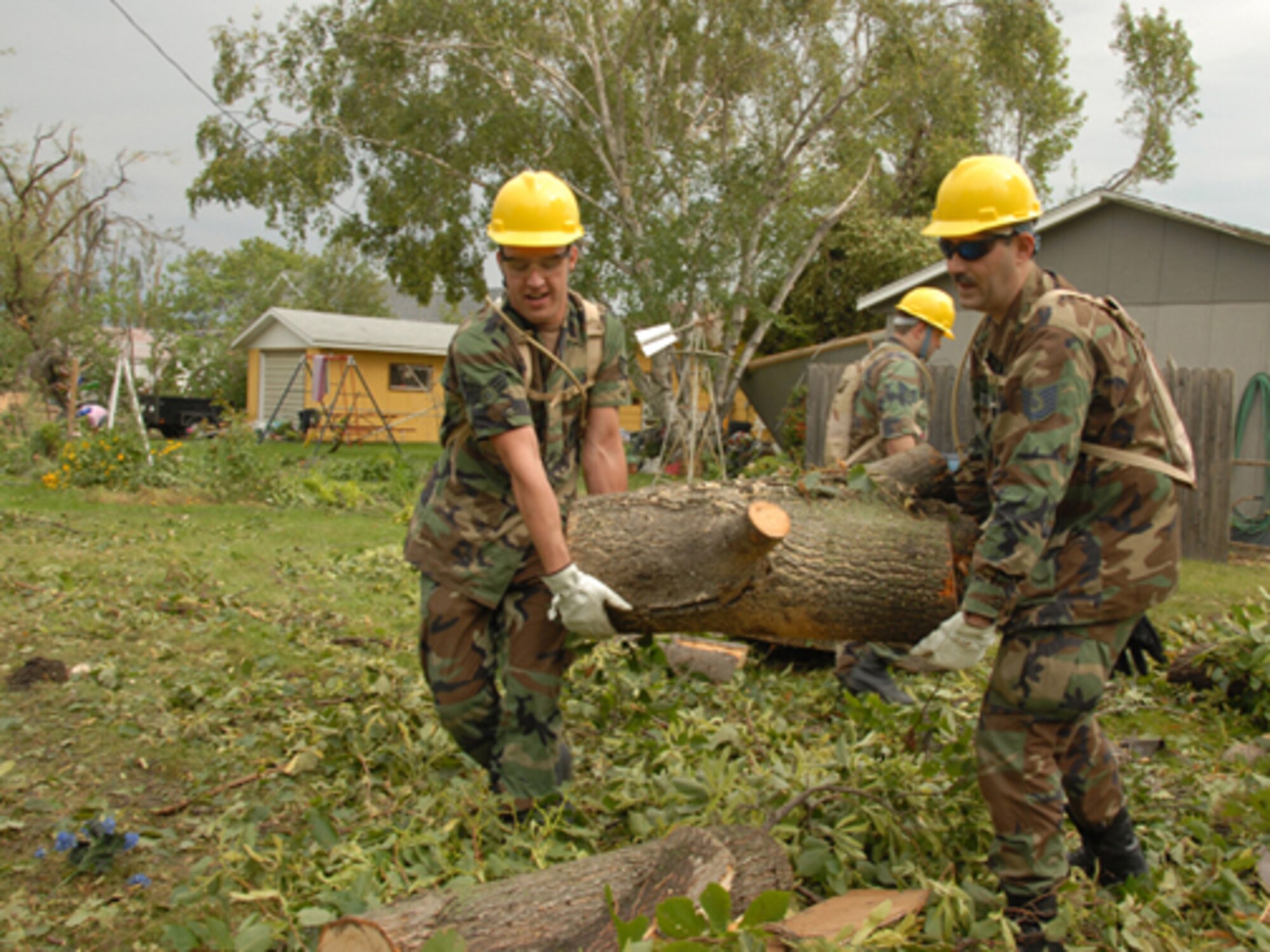 Senior Airman Brandon W. Miller, left, and Tech. Sgt. Richard M. Hayes, both of the 119th Wing, remove fallen tree branches and debris from yards in order to clear a path for power line workers in Northwood, N.D. Aug. 28.  The fallen trees are a result of an F4 category tornado that hit Northwood, N.D., in the early evening hours of Sunday, Aug. 26. (USAF photo/Senior Master Sgt. David H. Lipp)