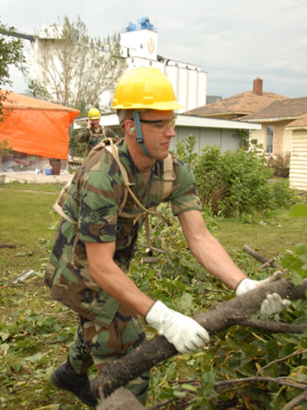 Senior Airman Brandon W. Miller, 119th Wing, removes fallen tree branches and debris from yards in order to clear a path for power line workers, Aug. 28, in Northwood, N.D.  The fallen trees are a result of an F4 category tornado that hit Northwood, N.D., in the early evening hours of Sunday, Aug. 26. (USAF photo/Senior Master Sgt. David H. Lipp)