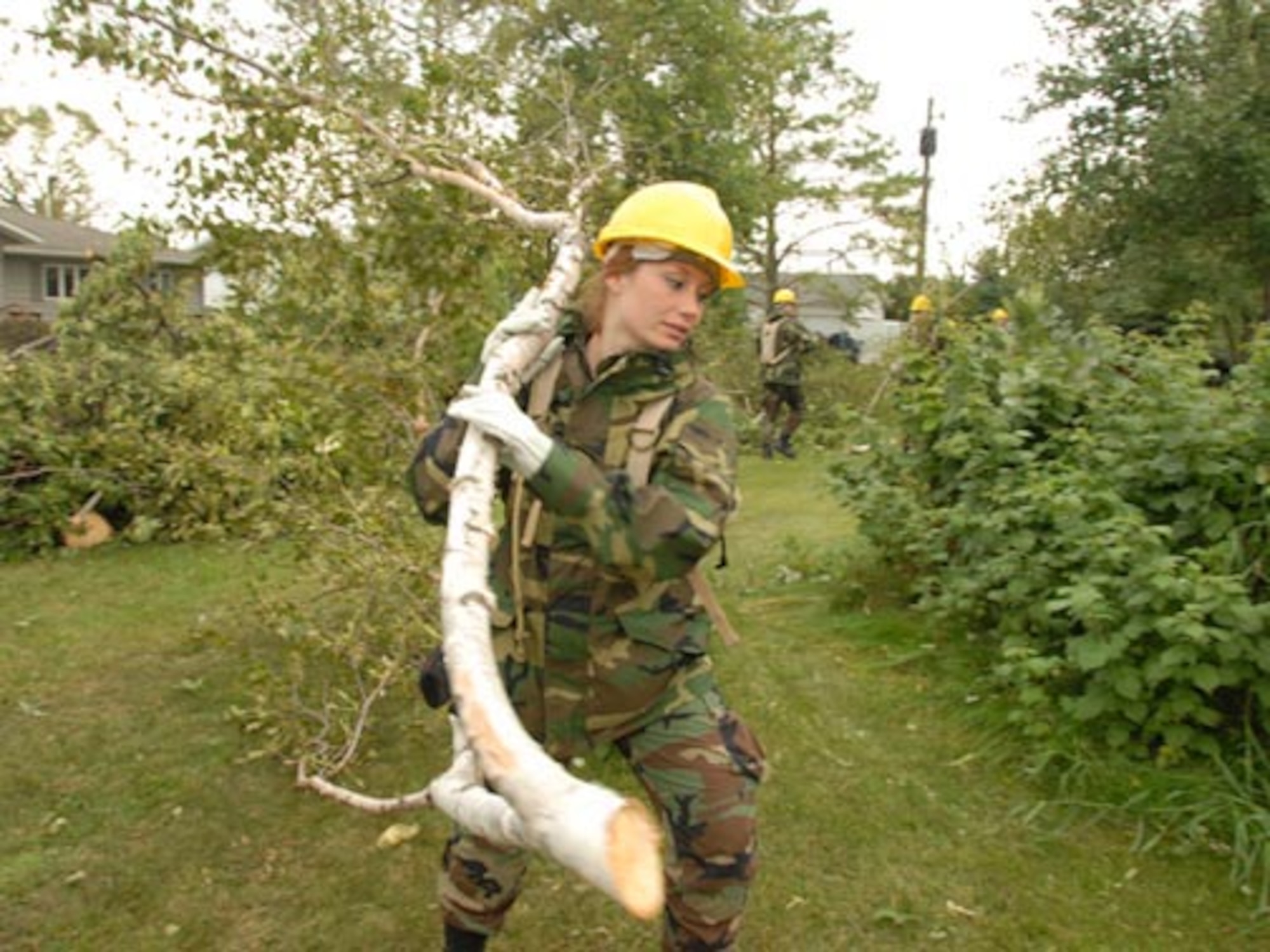 U.S. Air Force Staff Sgt. Sarah A. Ford, of the 119th Wing, removes fallen tree branches and debris from yards in order to clear a path for power line workers in Northwood, N.D., Aug. 28, 2007. A Fujita scale F-4 tornado that hit the city on Aug. 26, 2007 caused the damage. (U.S. Air Force photo by Senior Master Sgt. David H. Lipp) (Released)