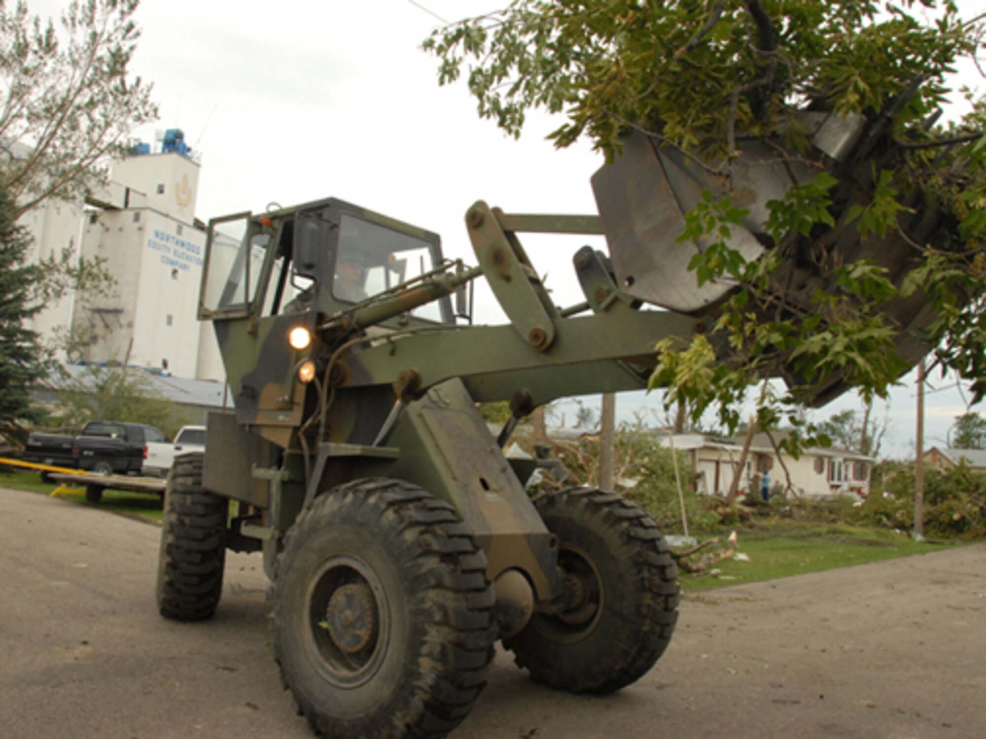 Private Nathan L. Miller, Detachment 2, 815th Engineer Company, uses a front end loader to clear downed trees and debris, Aug 28, left behind by an F4 category tornado, that hit Northwood, N.D., in the early evening hours of Sunday, Aug. 26.  (USAF photo/Senior Master Sgt. David H. Lipp) 