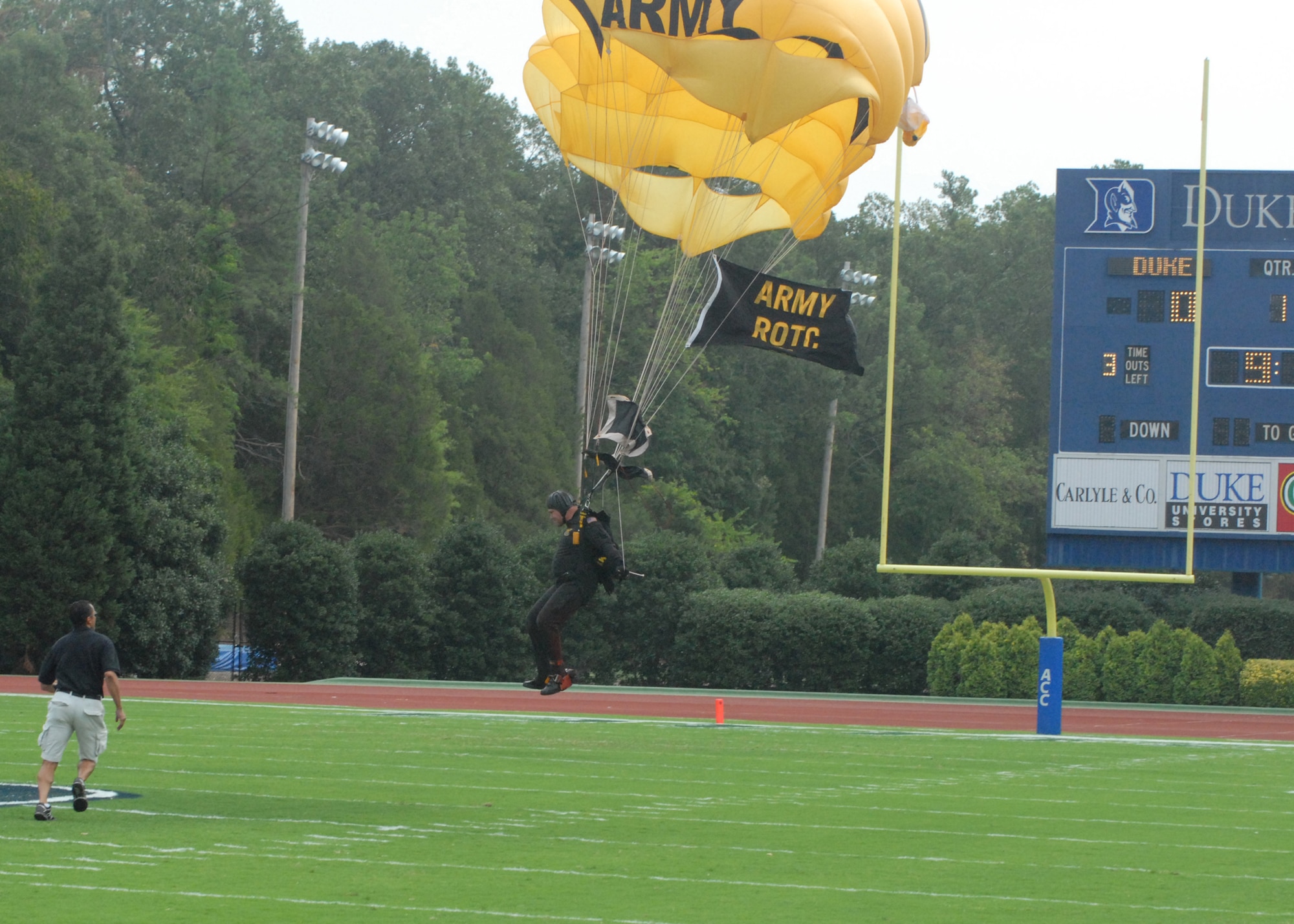 A member of the Army Golden Knights Parachute Team from Fort Bragg, N.C., approaches the target zone while flying the Army Reserve Offficer Training Corps flag Sept. 1 at Wallace Wade Stadium, Durham, N.C. Two members of the Golden Knights landed midfield to kick off the start of Duke's college football season as part of Duke's Military Appreciation Game. (U.S. Air Force photo/Staff Sgt. Jon LaDue)