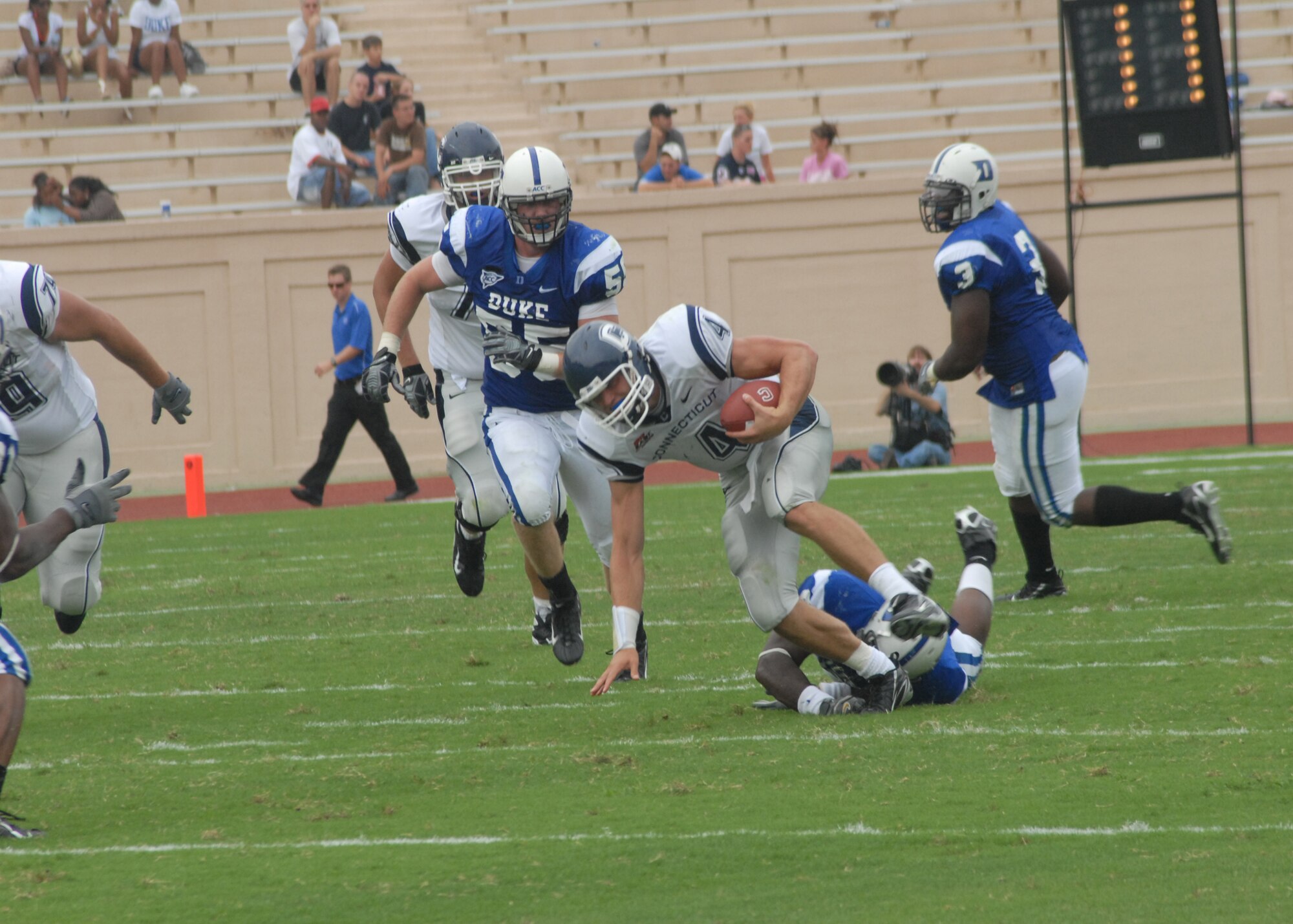 Conneticut Huskies quarterback Tyler Lorenzen eludes a Duke Blue Devils defender in the first half of their college football season opener Sept. 1. The Duke Athletic Department hosted its fourth annual Military Appreciation Game to start the season. (U.S. Air Force photo/Staff Sgt. Jon LaDue)