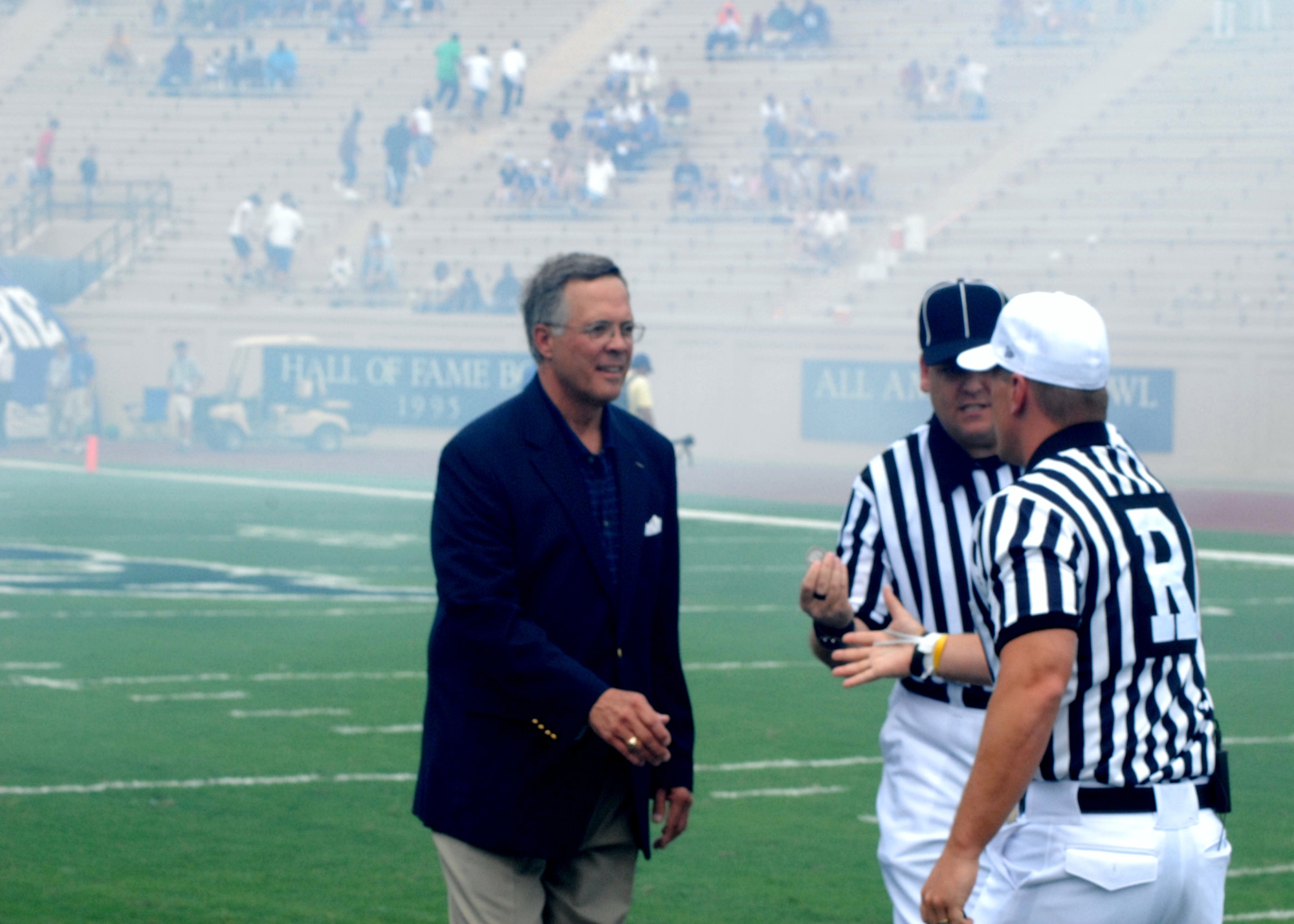 John McNabb, Duke Alumni and former Air Force aviator, meets with referee's following player introductions at the Duke Blue Devils vs. Conneticut Huskies football game. Mr. McNabb, awarded the Distinguished Flying Cross and Air Medal with Three Oak Leaf Clusters for actions in the Vietnam War, presented the opening coin toss on behalf of all Duke Alumni who have served in the military. (U.S. Air Force photo/Staff Sgt. Jon LaDue)