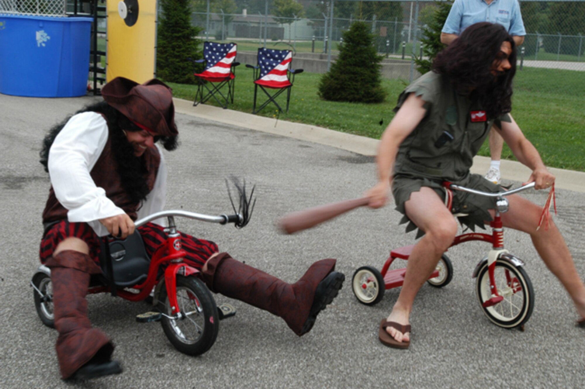GRISSOM AIR RESERVE BASE, Ind., -- The caveman (Col. Randy Ogden) ensures the pirate (Lt. Col. Paul Wietbrock) falls behind during the commanders' tricycle race during family day activities at Grissom.  For the tricycle race, commanders don colorful costumes and attempt to be the first across the finish line.  (U.S. Air Force photo/Senior Airman Mark Orders-Woempner)
