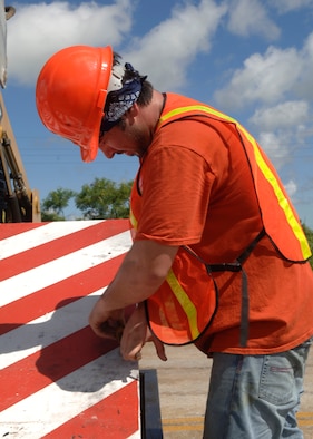 ANDERSEN AFB – Brandt Naito, GSA construction worker, loosens a bolt on a barrier being installed for added security measures here recently. Construction started Aug. 29 with an estimated completion date of Sept.  20. (USAF Photo by Senior Airman Sonya Padilla)