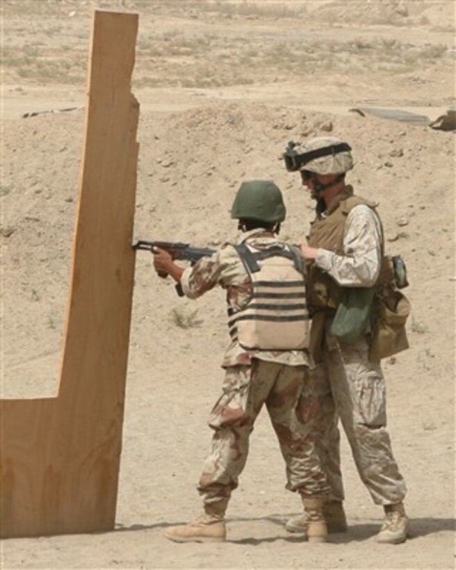 A U.S. Marine guides an Iraqi army soldier during weapons training at Joint Security Station Iron in Ramadi, Iraq, on Sept. 6, 2007.  Marines from the 2nd Battalion, 5th Marine Regiment are instructing the Iraqis in proper weapons handling.  