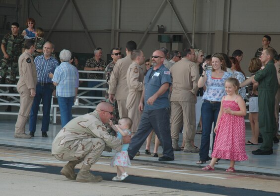 Staff Sgt. Gentry A. Nickell, 719th Maintenance Squadron, picks up his 13-month-old daughter, Bria, after he got to see her walk for the first time Sept. 7. Sergeant Nickell was one of 40 wing members returning from the last summer rotation to Southwest Asia. (U.S. Air Force Photo\Jasmine DeNamur) 