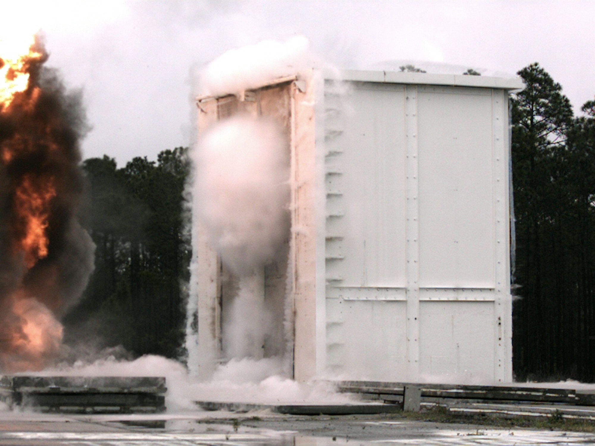 Blast pressure hitting these pre-cast concrete wall panels creates water vapor clouds that evaporate a couple milliseconds later.  Air Force Research Laboratory's Materials and Manufacturing Directorate is engaged in a cooperative research effort at Tyndall Air Force Base to determine blast resistance of insulated concrete products. (U.S. Air Force)
