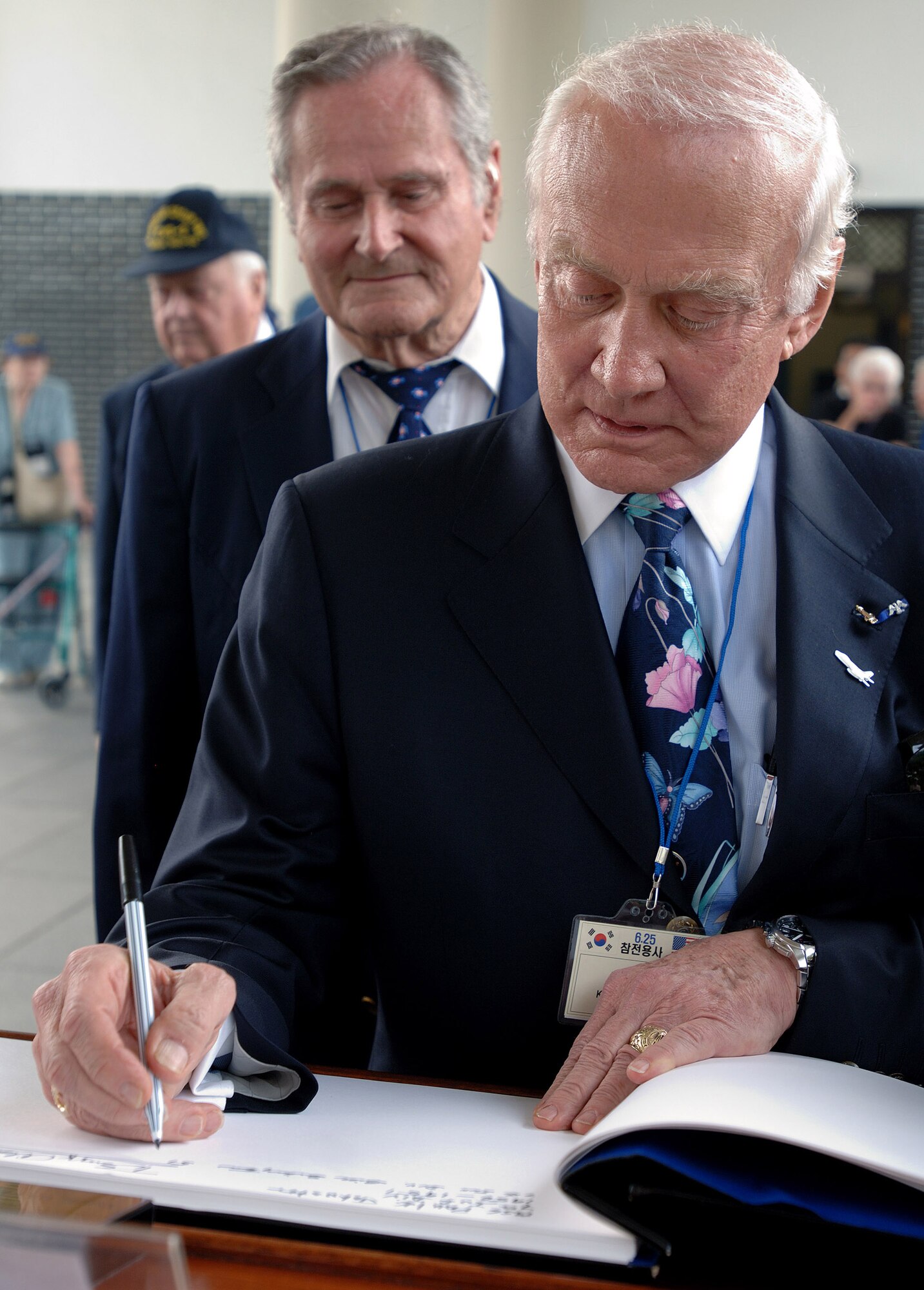 Apollo 11 astronaut and retired Col. Buzz Aldrin signs a guest book after a wreath-laying ceremony at the South Korean National Cemetery Sept. 12. Colonel Aldrin is a veteran of the war and is credited with two confirmed MiG kills while flying the F-86 Sabre. (U.S. Air Force photo/Staff Sgt. Bennie J. Davis III) 
