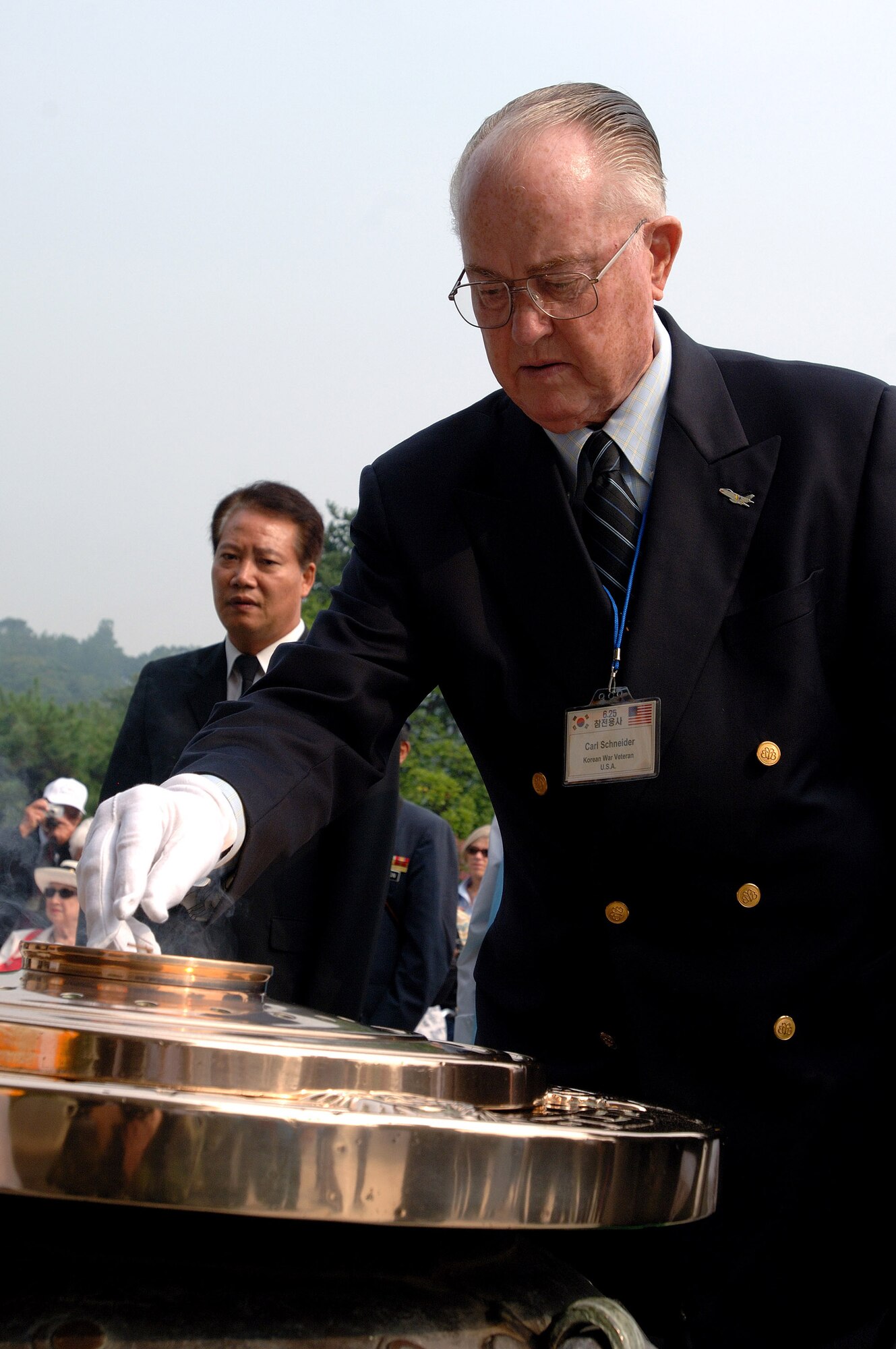 Retired Maj. Gen. Carl G. Schneider pours incense into a flame to honor Korean War veterans during a ceremony at the South Korean National Cemetery Sept. 12. The South Korean government's Revisit Korea program invites war veterans each year to come to South Korea to honor the men and woman from 21 countries who served during the Korean War. Nearly 25,000 veterans have participated in this program since 1975. (U.S. Air Force photo/Staff Sgt. Bennie J. Davis III) 
