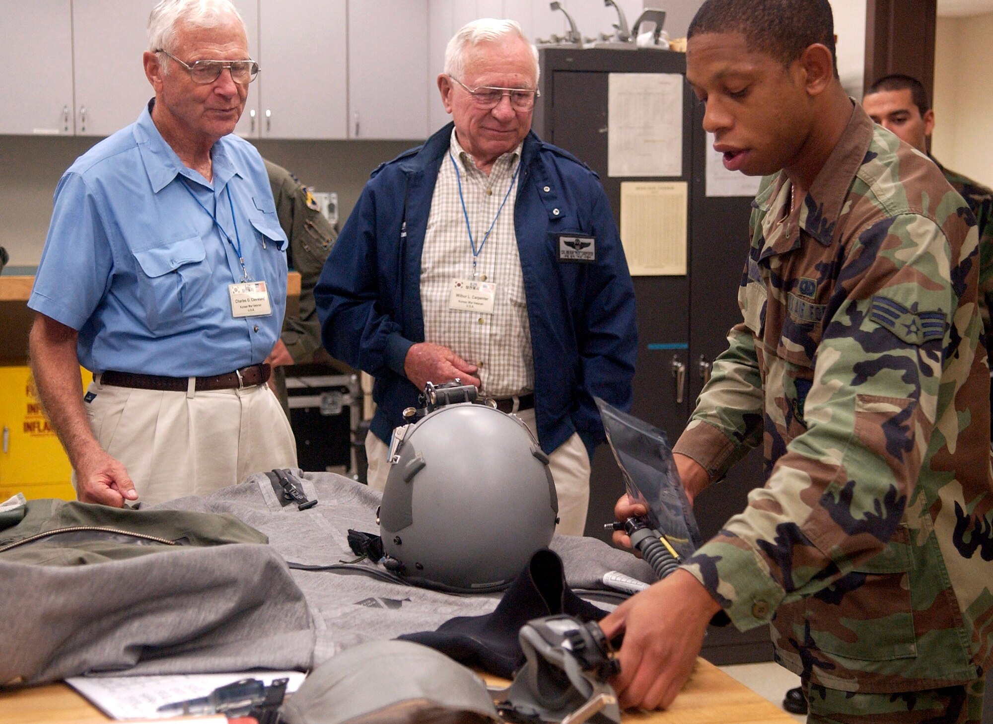 Senior Airman Cortney Tanner shows some of the life support equipment used by today's pilots to Korean War veterans Lt. Gen. Charles Cleveland (left) and Col. Wilbur Carpenter Sept. 11 at Kunsan Air Base, South Korea.  The veterans were visiting Kunsan and sharing their flying experiences with 8th Fighter Wing Airmen.  Airman Tanner is a life support journeyman with the 35th Fighter Squadron.  (U.S. Air Force photo/Senior Airman Giang Nguyen) 