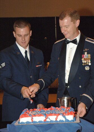 Senior Airman Myles Alexander, 315th Aircraft Maintenance Squadron aerospace maintenance apprentice, helps Col. John "Red" Millander, 437th Airlift Wing commander, in the cake cutting ceremony at the Air Force Ball at the Embassy Suites North Charleston Saturday. (U.S. Sir Force photo/Airman 1st Class Cynthia Spalding)