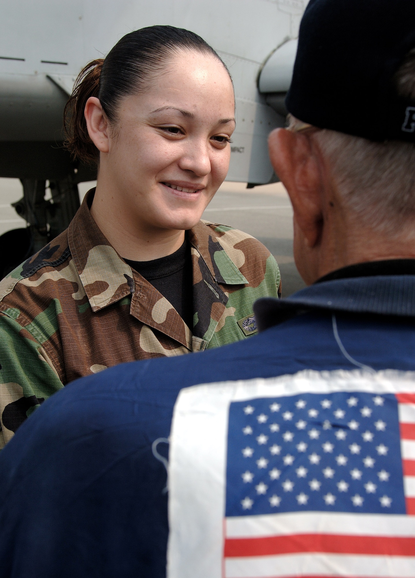 Texas native Senior Airman Stephanie Lopez talks with retired Lt. Col. Harold Fischer about living in San Antonio during a Sept. 11 tour of Osan Air Base, South Korea. Colonel Fischer and seven other Korean War veterans are visiting South Korea during a weeklong tour in observance of the Air Force's 60th Anniversary. Colonel Fischer is a Korean War double ace. (U.S. Air Force photo/Staff Sgt. Bennie J. Davis III) 
