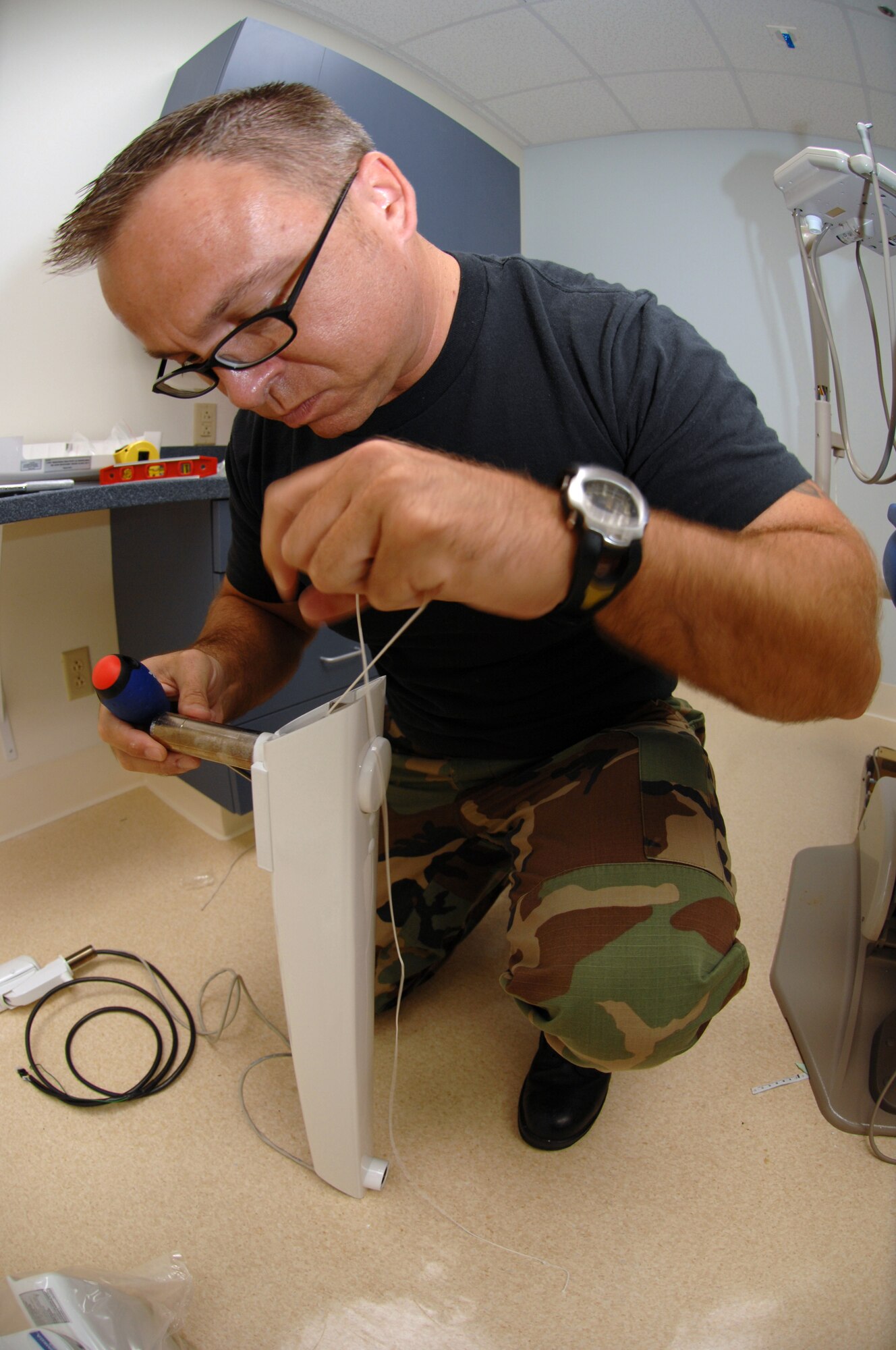 SEYMOUR JOHNSON AIR FORCE BASE, N.C. - Tech. Sgt. Christian Ziermann, 4th Medical Support Squadron, bio medical equipment repair technician, runs wire through the arm of the inner-oral x-ray unit September 6. The new equipment being installed is part of a $3.7 million renovation project. (U.S. Air Force photo by Airman First Class Salma Din)