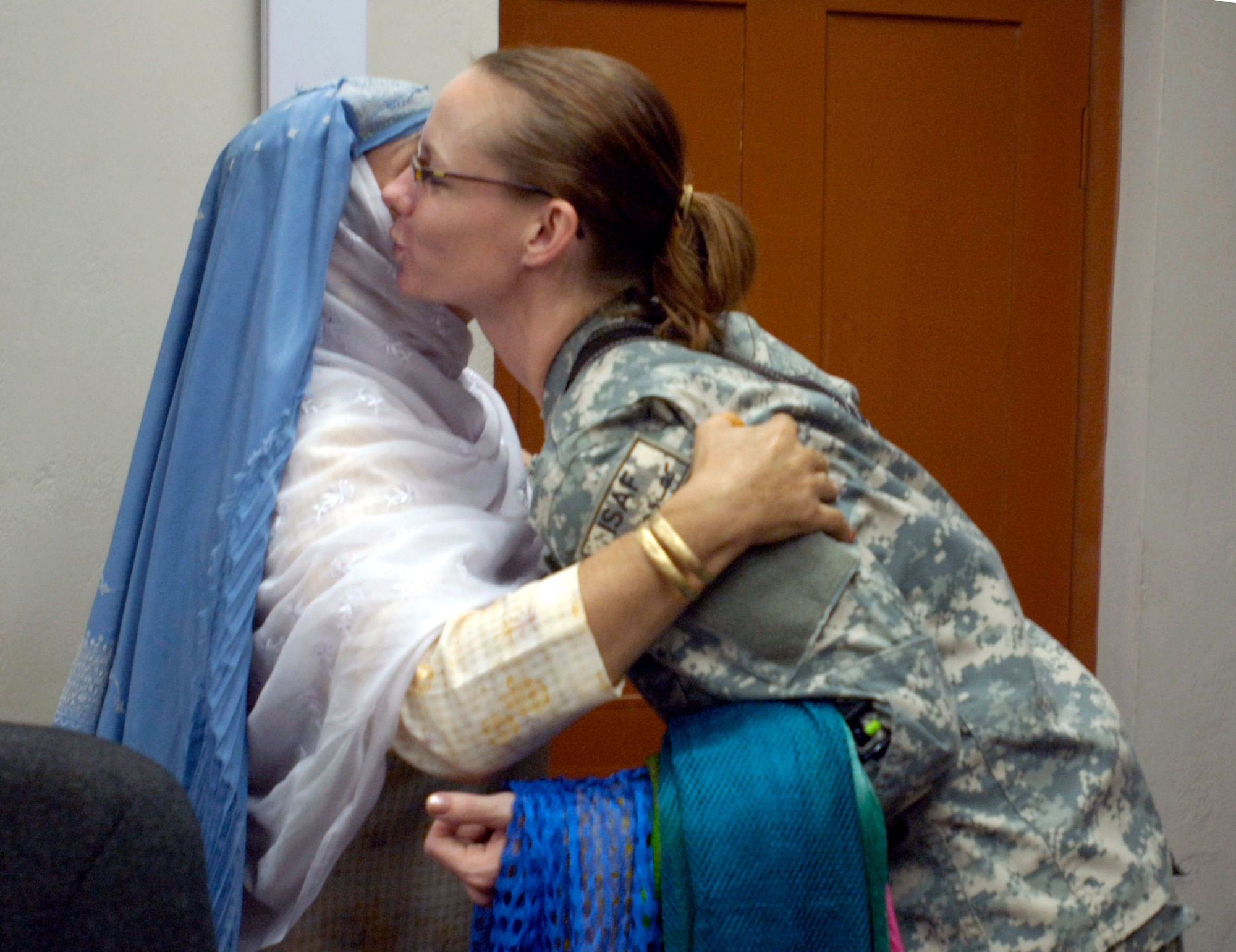 Capt. Heather Kekic shares a traditional greeting with an Afghan woman during an afternoon tea Sept. 5 at Forward Operating Base Mehtar Lam, Afghanistan. Female Airmen and Soldiers assigned to the Laghman Provincial Reconstruction Team hosted the tea for influential Afghan women living throughout Afghanistan's Laghman province. The tea provides an opportunity for PRT members to educate the local women on humanitarian and security programs in place for them and their communities. Captain Kekic, the PRT's public affairs and information officer, is deployed from Randolph Air Force Base, Texas. (U.S. Air Force photo/Staff Sgt. Julie Weckerlein)