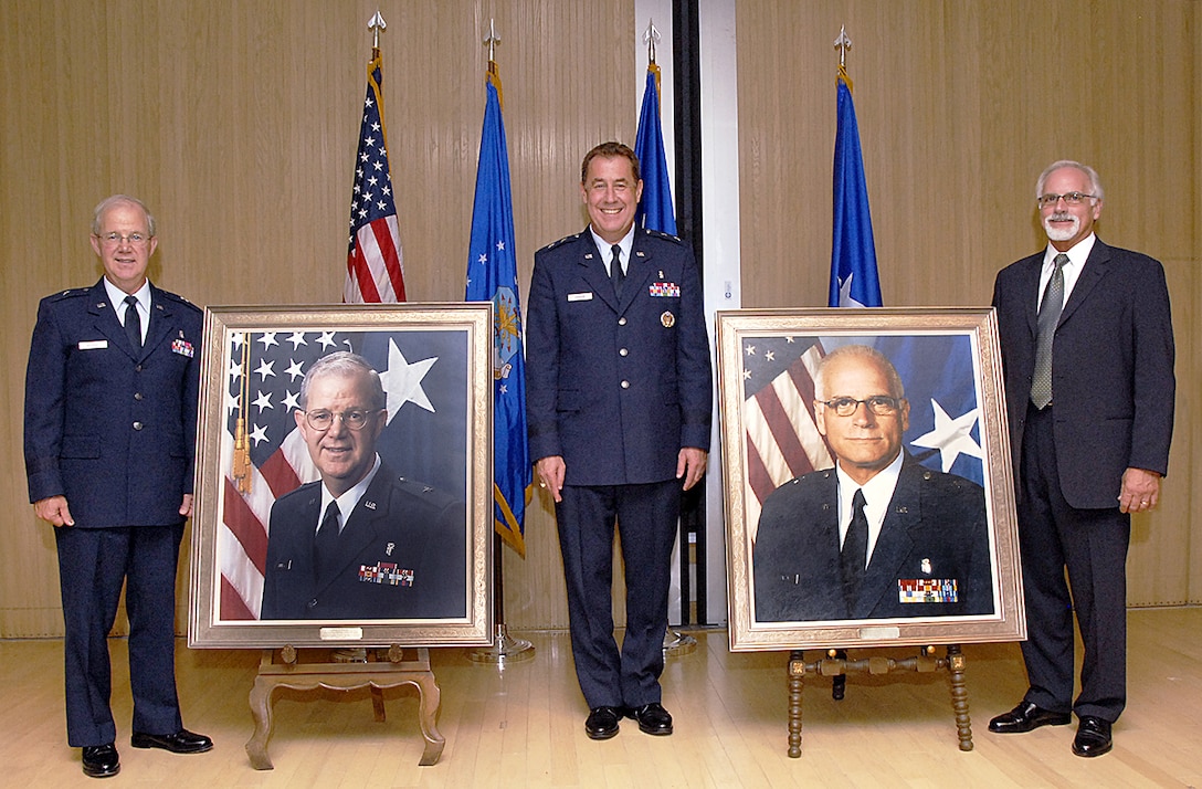 Retired Brig. Gen. Gary Murray, Maj. Gen. Gar Graham and retired Brig. Gen. Thomas Bailey stand beside the portraits of Generals Murray and Bailey that were unveiled in a ceremony Sept. 10.  Generals Murray and Bailey are former chiefs of the Air Force Dental Corps. (U.S. Air Force photo/Harry Tonemah)