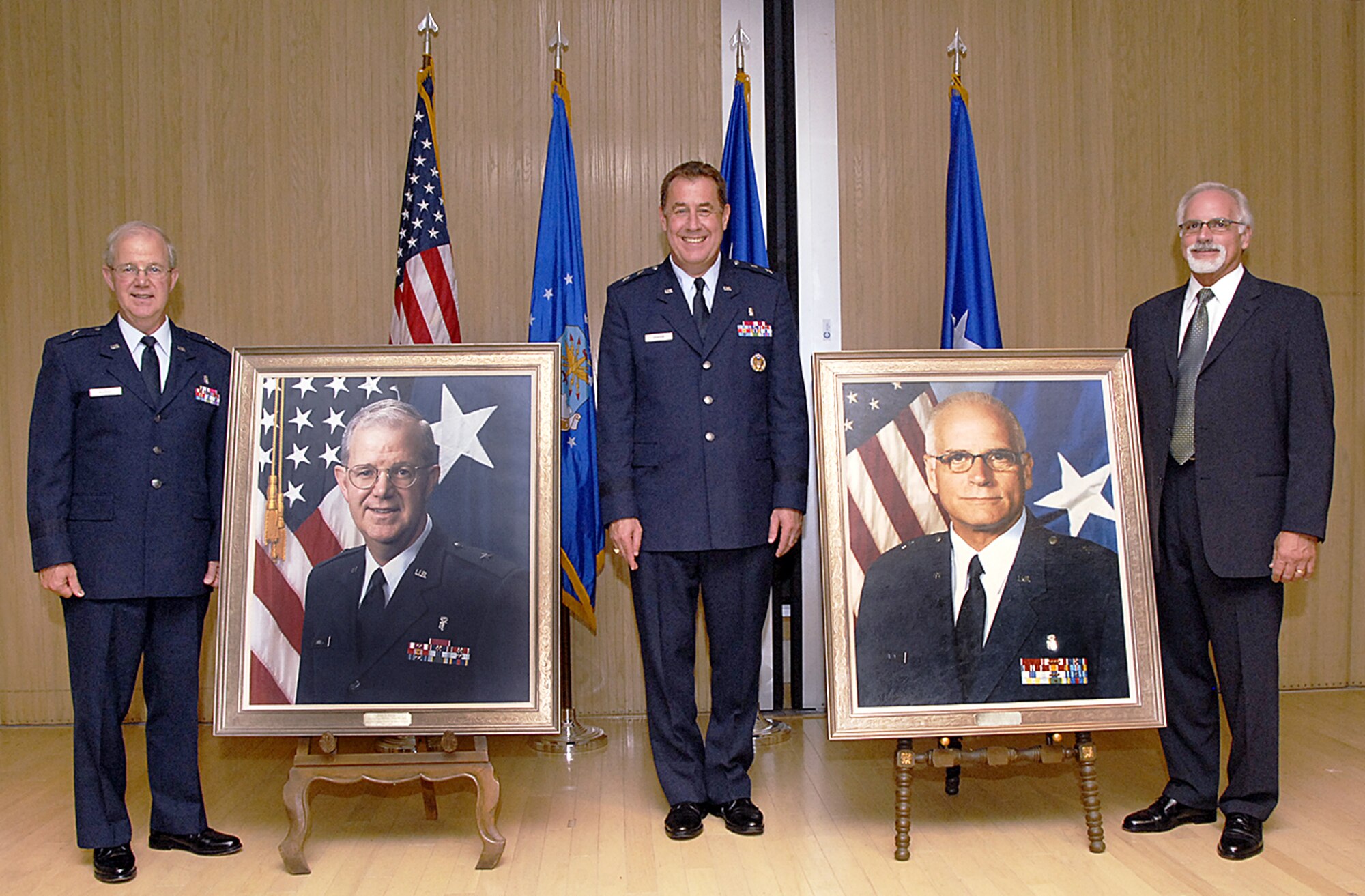 Retired Brig. Gen. Gary Murray, Maj. Gen. Gar Graham and retired Brig. Gen. Thomas Bailey stand beside the portraits of Generals Murray and Bailey that were unveiled in a ceremony Sept. 10.  Generals Murray and Bailey are former chiefs of the Air Force Dental Corps. (U.S. Air Force photo/Harry Tonemah)