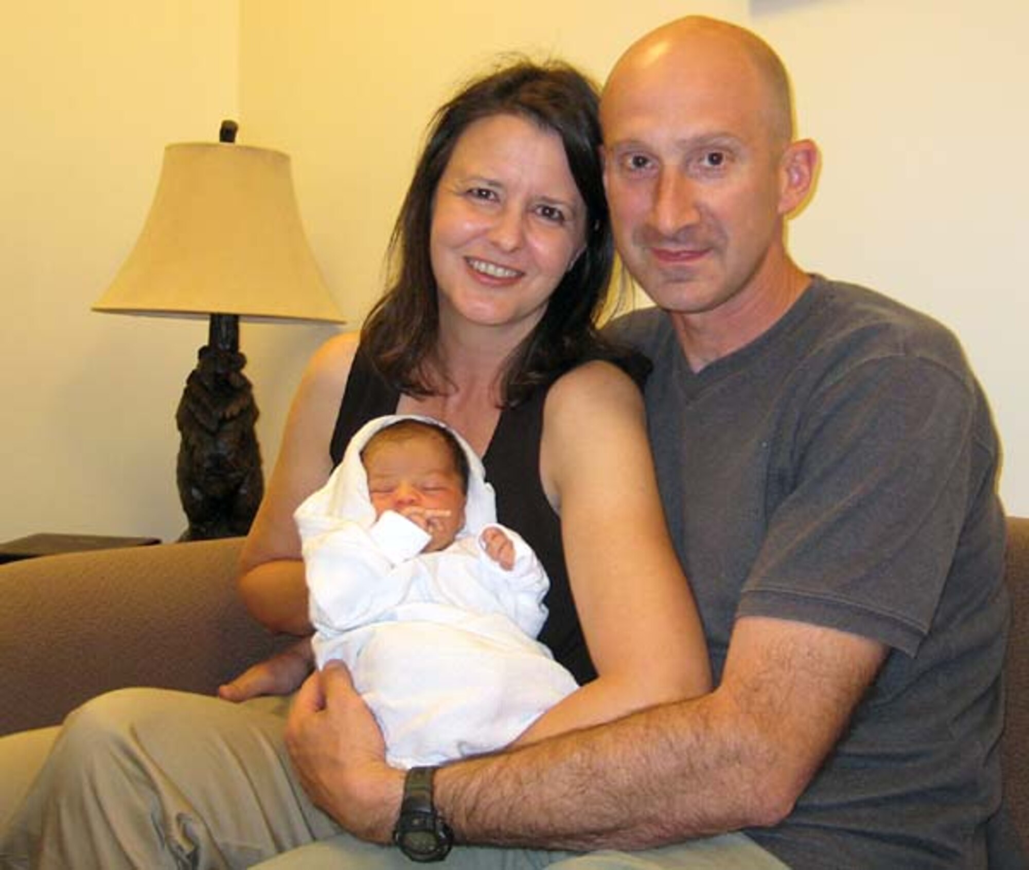 BAGRAM AIRFIELD, Afghanistan -- Air Force Lt. Col. Marc Piccolo and his wife Rhonda hold their new son, Joseph, Aug. 12, 2007.  After a 10-month wait, the Piccolos were finally able to adopt the day before he deployed here for six months. (Courtesy Photo)