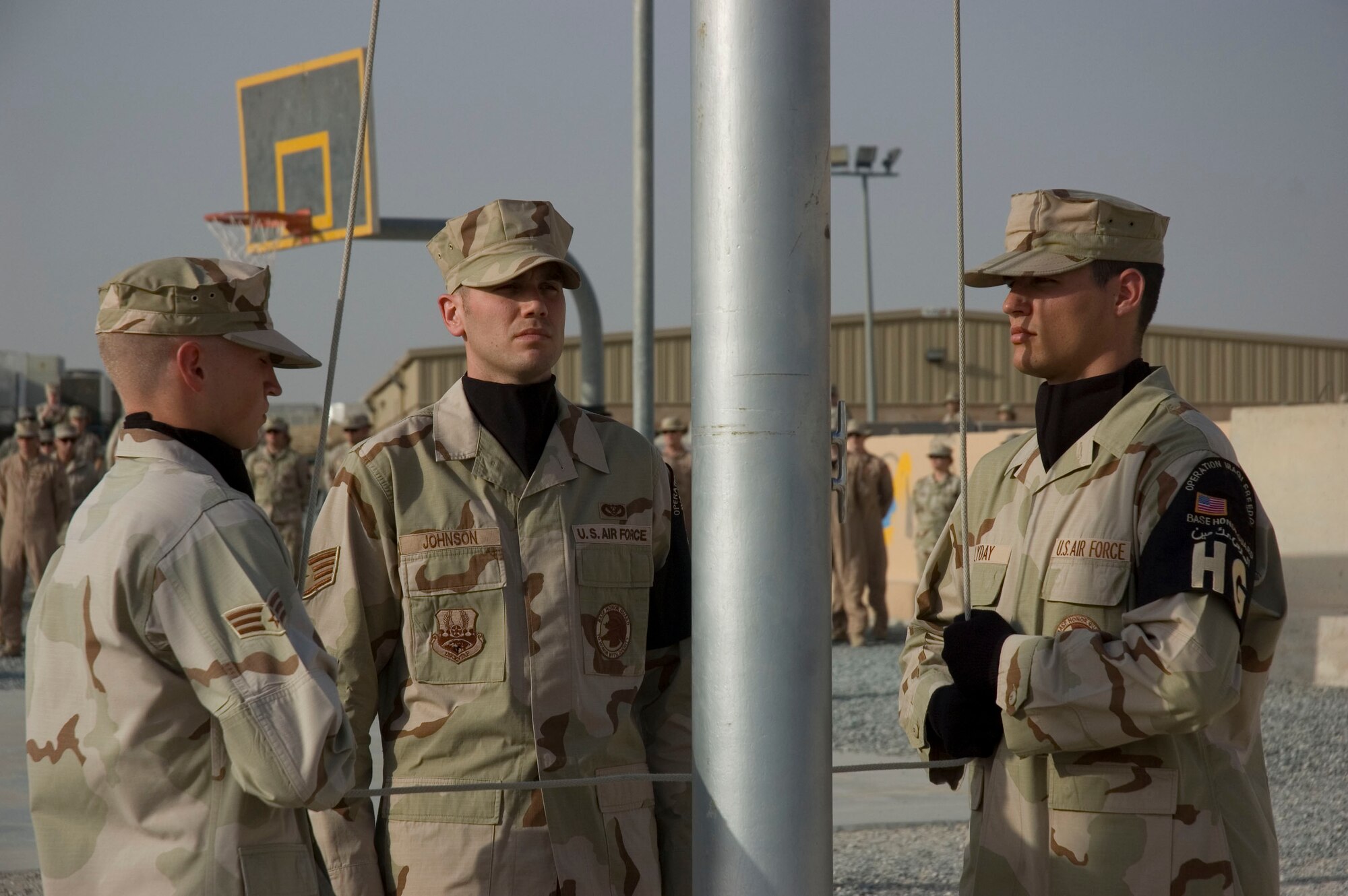 (L to R) Senior Airman Blaine Andrews, Staff Sgt. Brian Johnson, and Senior Airman Roger Lyday from the 386th Air Expeditionary Wing Honor Guard lower the flag during a tribute to the men and women who lost their lives during the Sept. 11, 2001, remembrance ceremony Sept. 11 at an undisclosed location in S.W. Asia. The ceremony marked the sixth anniversary of the terrorist attacks in New York City, the Pentagon and Shanksville, Pa. (U.S. Air Force photo illustration by SSgt Tia Schroeder)