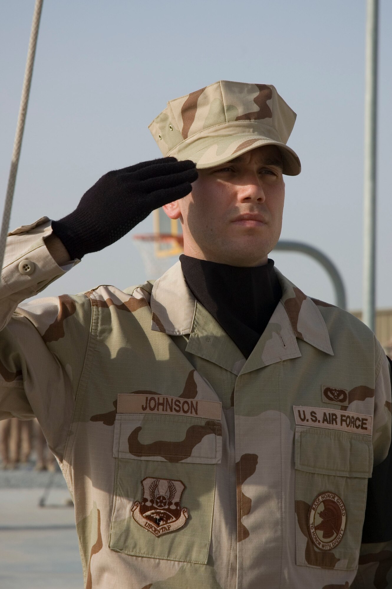 Honor Guardsmen Staff Sergeant Brian Johnson from the 386th Air Expeditionary Wing, renders a salute as the flag is lowered during a tribute to the men and women who lost their lives during the Sept. 11, 2001, remembrance ceremony Sept. 11 at an undisclosed location in S.W. Asia. The ceremony marked the sixth anniversary of the terrorist attacks in New York City, the Pentagon and Shanksville, Pa. (U.S. Air Force photo illustration by SSgt Tia Schroeder)