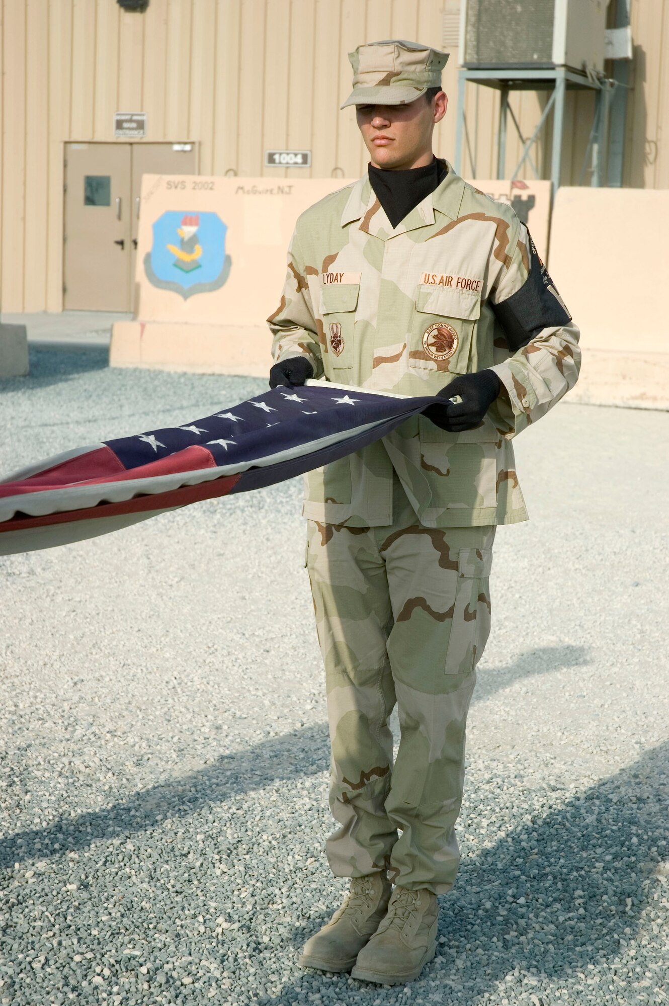 Honor Guardsmen Senior Airman Roger Lyday from the 386th Air Expeditionary Wing, performs a flag folding to pay tribute to the men and women who lost their lives during the Sept. 11, 2001, remembrance ceremony Sept. 11 at an undisclosed location in S.W. Asia. The ceremony marked the sixth anniversary of the terrorist attacks in New York City, the Pentagon and Shanksville, Pa. (U.S. Air Force photo illustration by SSgt Tia Schroeder)