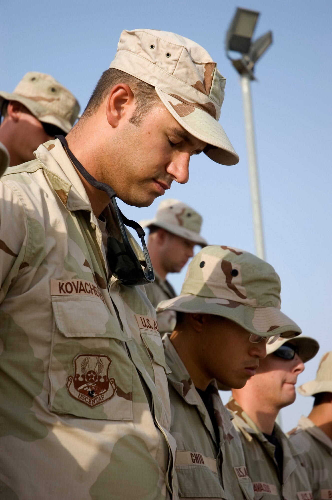 Airmen from the 386th Air Expeditionary Wing pause for a moment of silence for the men and women who lost their lives during the Sept. 11, 2001, remembrance ceremony Sept. 11 at an undisclosed location in S.W. Asia. The ceremony marked the sixth anniversary of the terrorist attacks in New York City, the Pentagon and Shanksville, Pa. (U.S. Air Force photo illustration by SSgt Tia Schroeder)