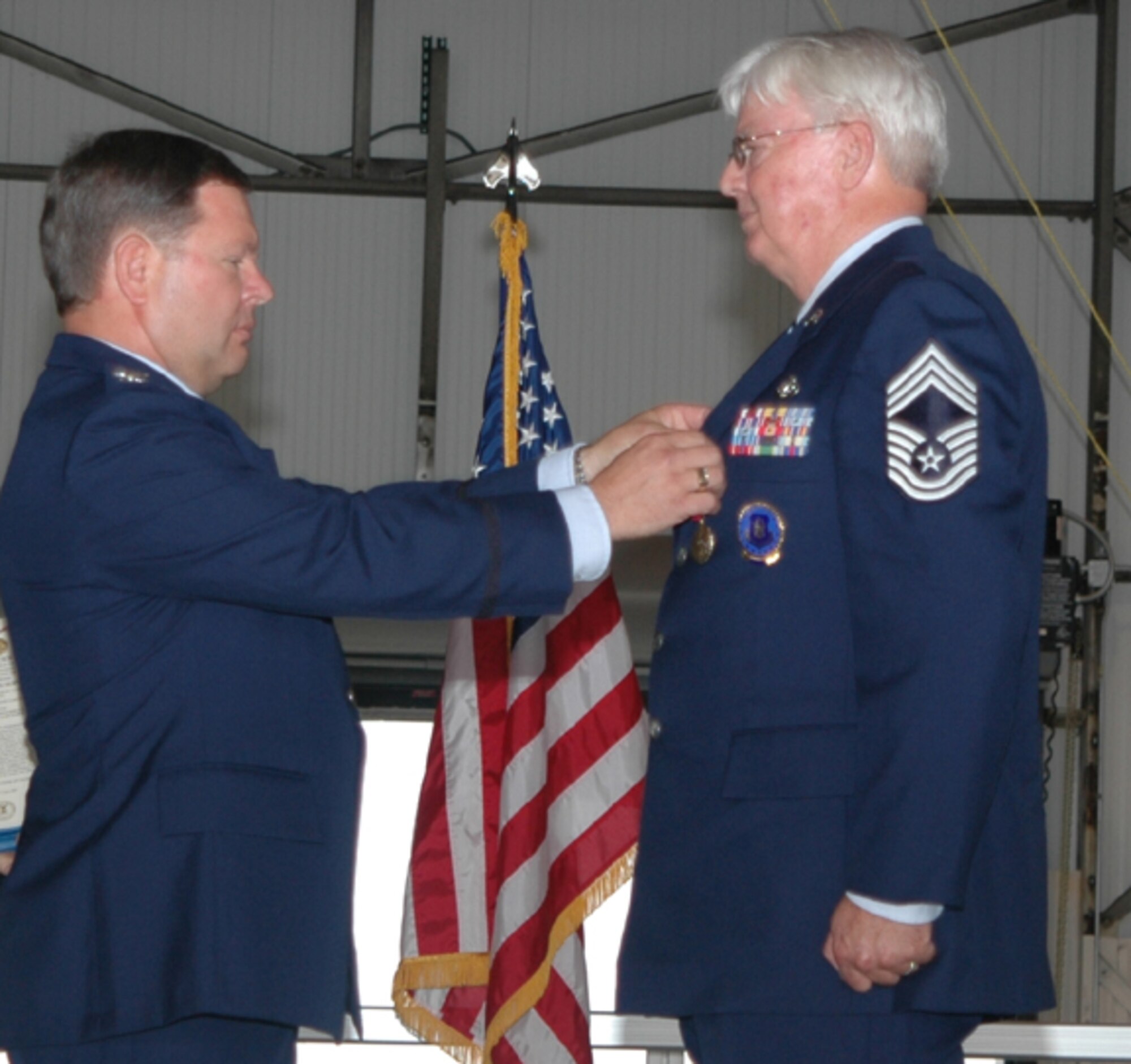 GRISSOM AIR RESERVE BASE, Ind., -- Col. Rick Maughmer, Air Force Reserve Command Recruiting Service, pins an Air Force Meritorious Service Medal on Chief Master Sgt. Gary Anderson's during a retirement ceremony at Grissom.  Chief Anderson was the senior recruiter at Grissom ARB prior to his retirement. (U.S. Air Force photo/Senior Airman Chris Bolen)