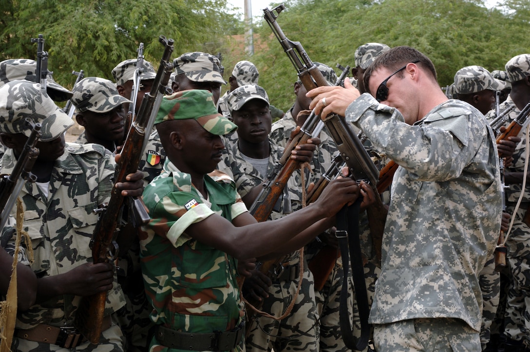 U.S. Army soldiers from the 3rd Special Forces Group deployed from Fort Bragg, N.C., help inspect Malian army soldiers’ weapons at their garrison in Tombouctou, Mali, Sept. 4, 2007, during exercise Flintlock 2007. The exercise is meant to foster relationships of peace, security and cooperation among the Trans-Sahara nations. 