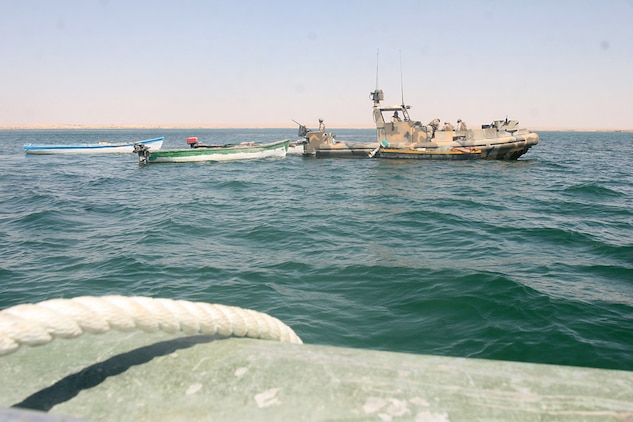 HADITHA DAM, Iraq, (Sept. 16, 2007) – A Riverine Patrol Boat with Riverine Squadron 1, Riverine Group 1, Navy Expeditionary Combat Command, in support of Regimental Combat Team 2, tows several boats the riverines seized in support of the new 24-hour curfew enforcement of the waterway near the dam. The riverines warned locals of the new curfew for several days before seizing the boats of repeat curfew offenders. Official Marine Corps Photo By Cpl. Ryan C. Heiser.