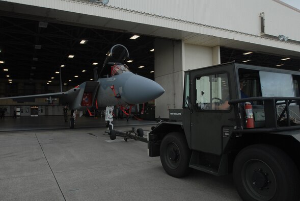 Kadena Airmen tow an F-15C Eagle fighter jet from the flightline into a hangar during preparation for Typhoon Nari on Sept. 14, 2007, at Kadena Air Base, Japan. The base prepared itself for typhoon by moving jets and equipment from the flightline into protective aircraft shelters. The typhoon will hit the island the evening of Sept. 14 with 45 knot winds gusting to 65 knots.  (U.S. Air Force photo/Senior Airman Darnell T. Cannady)