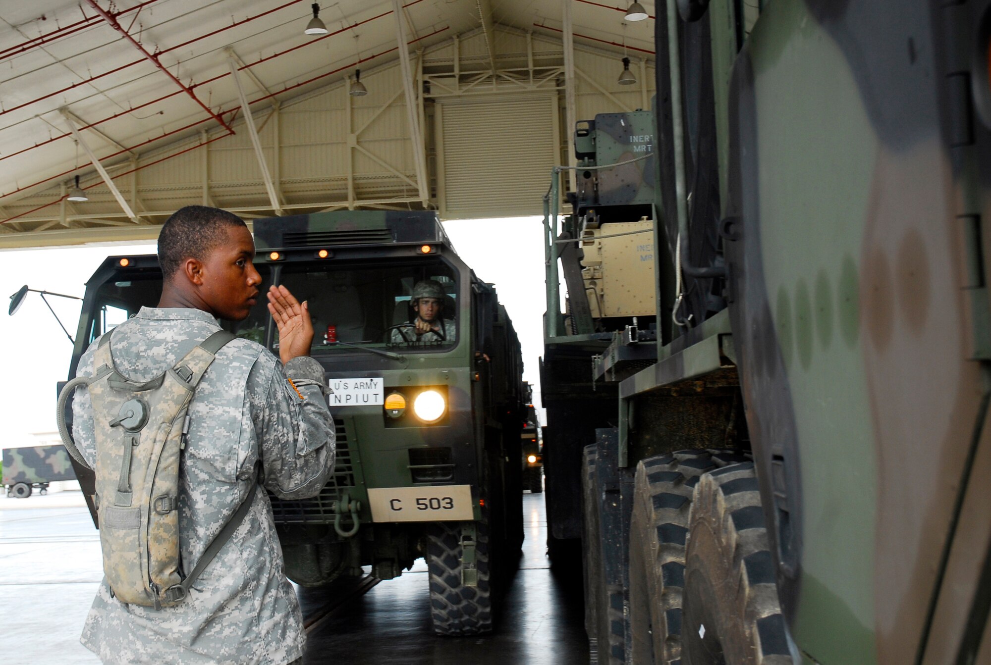 Private 1st Class Aaron Griges guides a truck loaded with Patriot missile equipment from the 1-1 Air Defense Artillery Battalion into a hangar as part of typhoon preparation at Kadena Air Base, Japan, Sept. 14, 2007. Typhoon Nari is the 2nd of the year for Okinawa and is expected to hit the island the evening of Sept. 14 with 45 knot winds gusting to 65 knots.  (U.S. Air Force photo/Airman 1st Class Sheila deVera)