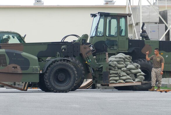 A Marine based at Kadena Air Base, Japan guides a forklift with a pallet as part of typhoon preparation Sept. 14, 2007. Typhoon Nari is the 2nd of the year for Okinawa and is expected to hit the island the evening of Sept. 14 with 45 knot winds gusting to 65 knots.  (U.S. Air Force photo/Airman 1st Class Sheila deVera)