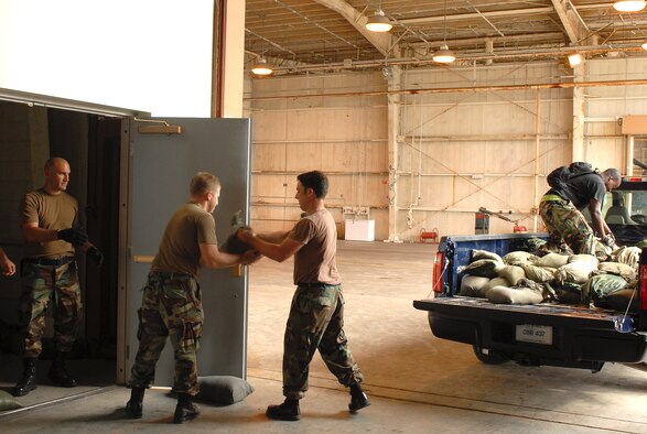 Airmen from the 33rd Rescue Squadron unload sandbags and stack them in front of where their tools are stored to keep water from Typhoon Nari from ruining them at Kadena Air Base, Japan, Sept. 14, 2007. The typhoon will hit the island the evening of Sept. 14 with 45 knot winds gusting to 65 knots. (U.S. Air Force photo/Airman 1st Class Kelly Timney)
