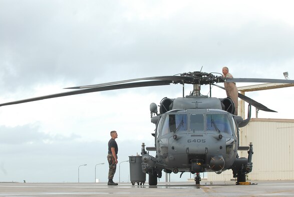 Members from the 33rd Rescue Squadron prep a HH-60 Helicopter for bed down during Typhoon Nari preparation at Kadena Air Base, Japan, Sept. 14, 2007. The base prepared itself for typhoon by moving jets and equipment from the flightline into protective aircraft shelters. The typhoon will hit the island the evening of Sept. 14 with 45 knot winds gusting to 65 knots.  (U.S. Air Force photo/Airman 1st Class Kelly Timney) 