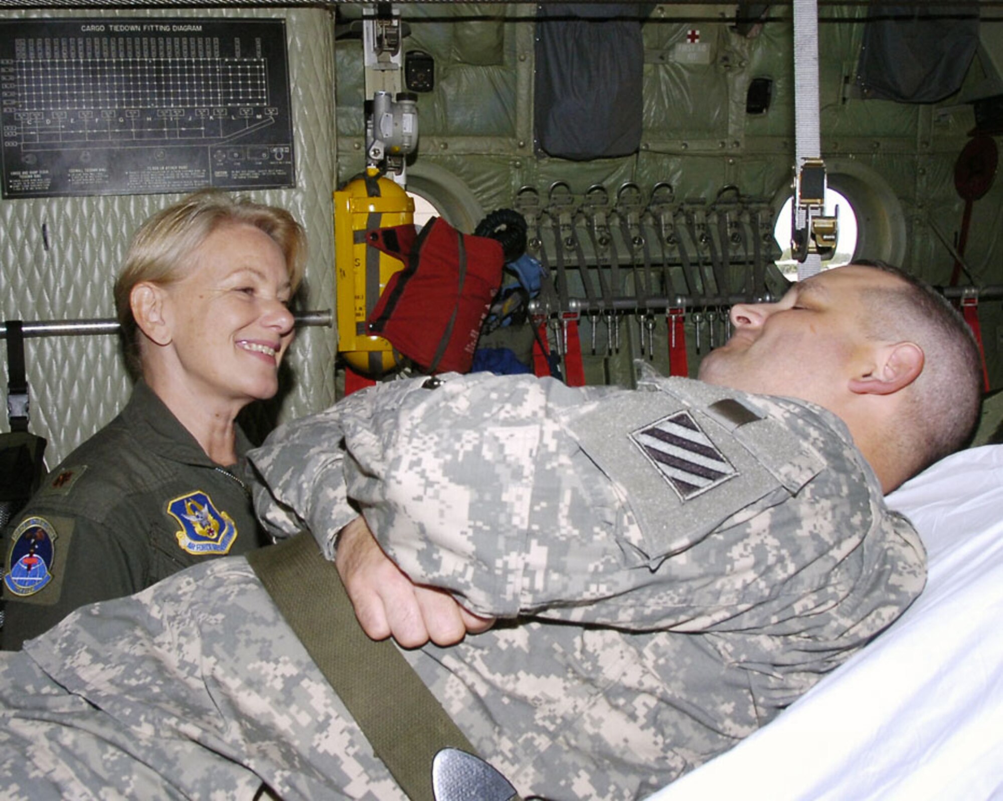 Lt. Col. Diana Copper talks with Army Staff Sgt. Walter J. McMaster inside an air medical evacuation configured C-130 aircraft prior to being transported to the next medical facility.