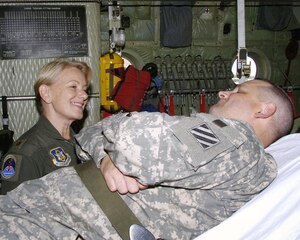 Lt. Col. Diana Copper talks with Army Staff Sgt. Walter J. McMaster inside an air medical evacuation configured C-130 aircraft prior to being transported to the next medical facility.