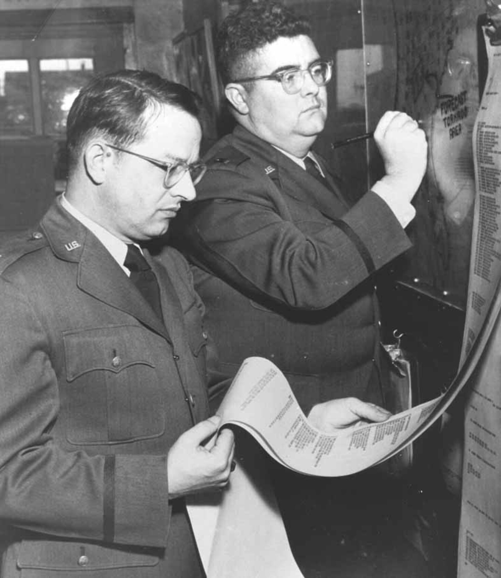 Maj. Ernest J. Fawbush, left, and Capt. Robert C. Miller study forecasting and meteorology documents and patterns before predicting a tornado March 25, 1948. They were the first in American history to forecast a tornado. (Air Force photo courtesy of Oklahoma City Air Logistics Center History Office)