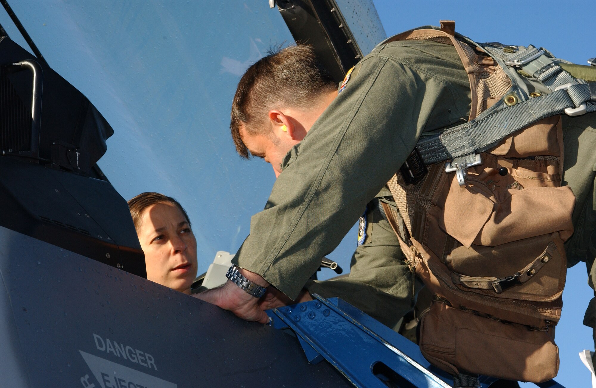 EIELSON AIR FORCE BASE, Alaska--Maj. Norman Johnsen, 354th Operations Support Squadron F-16 pilot, ensures Master Sgt. Deanna Croxen, Eielson Airman Leadership School instructor, is strapped in the jet properly before they begin her incentive flight Sept. 13. The incentive program's purpose is for group commanders to acknowledge the hard work and dedication of their Airmen. (U.S. Air Force photo by Airman 1st Class Nora Anton)                                