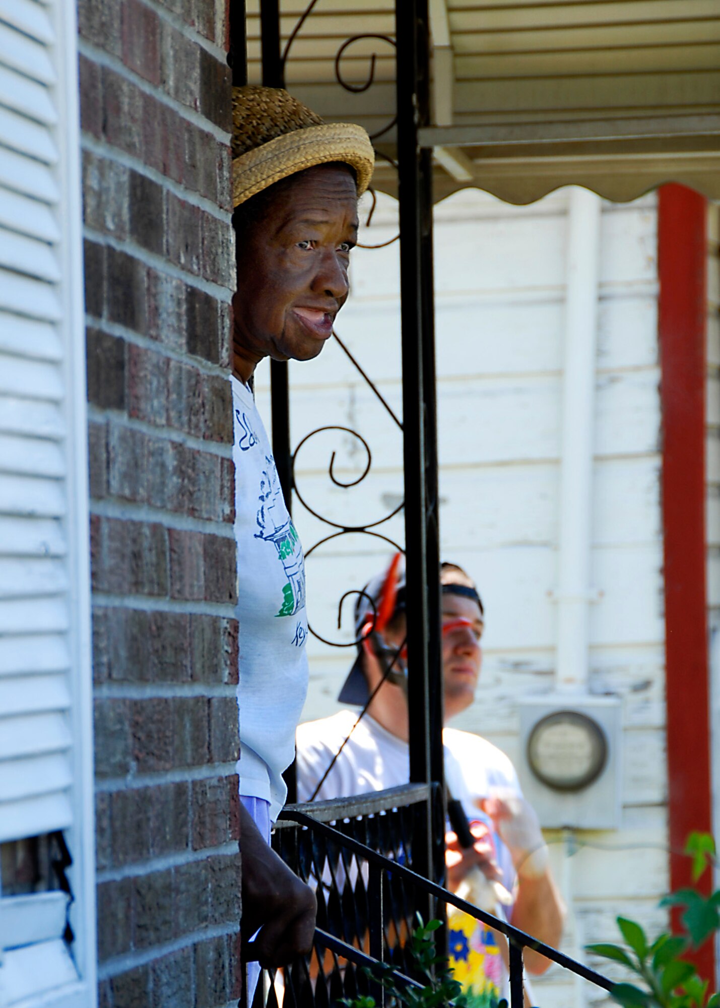 A resident of Rosemount neighborhood watches as military volunteers from Team Charleston and the Navy Nuclear Power Training Command help landscape her property. (photo by Capt. Chett Collier, USAFR)
