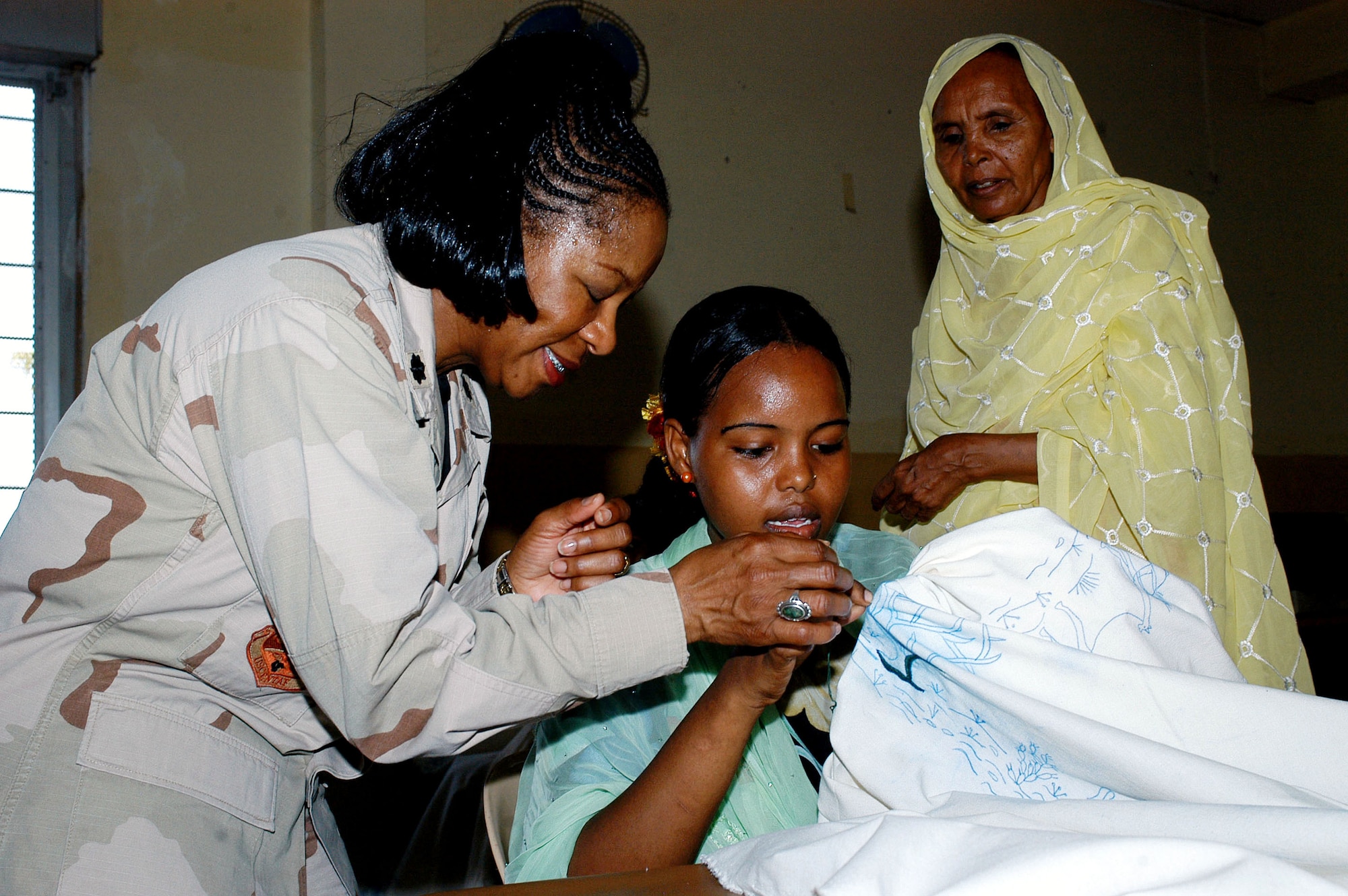 Chaplain (Lt. Col.) Oledia Bell works with a student Sept. 10 at the Union National of the Djibouti Women in Djibouti. The Union National of the Djibouti Women provides job skills training to Djiboutian women. The material is part of a donation received by the Union National of the Djibouti Women, which included a sewing machine, sewing materials, and pens and notebooks. The donation was part of Operation Hand Clasp and delivered by members of the Combined Joint Task Force - Horn of Africa Chaplain's office. (U.S. Navy photo/Petty Officer 1st Class John Osborne) 